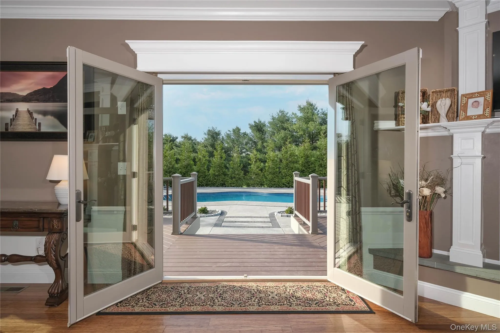 View from living room to expansive deck and pool complex beyond. View from living room to expansive deck and pool complex beyond.