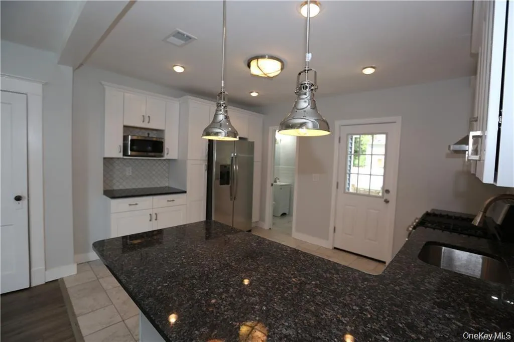 Stunningly updated kitchen with granite counters and pendant lighting Stunningly updated kitchen with granite counters and pendant lighting