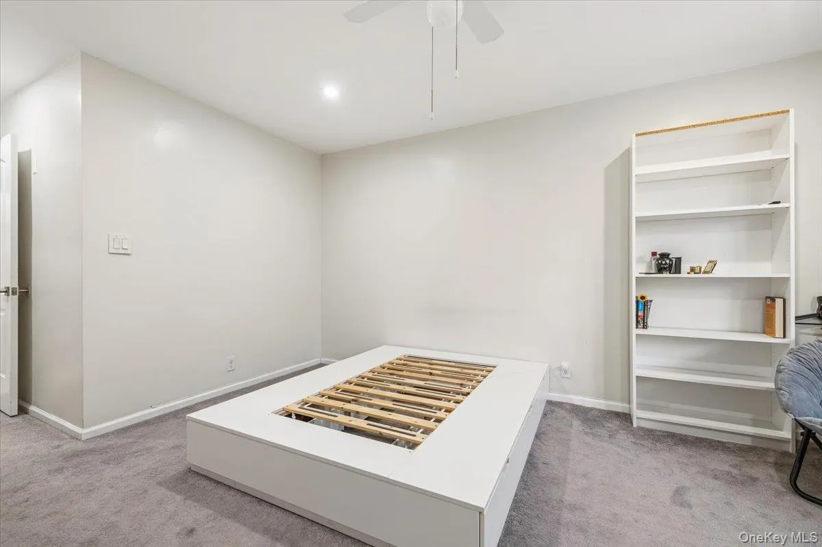 Neutral wall color with recessed lighting, ceiling fan, and grey carpeting Neutral wall color with recessed lighting, ceiling fan, and grey carpeting