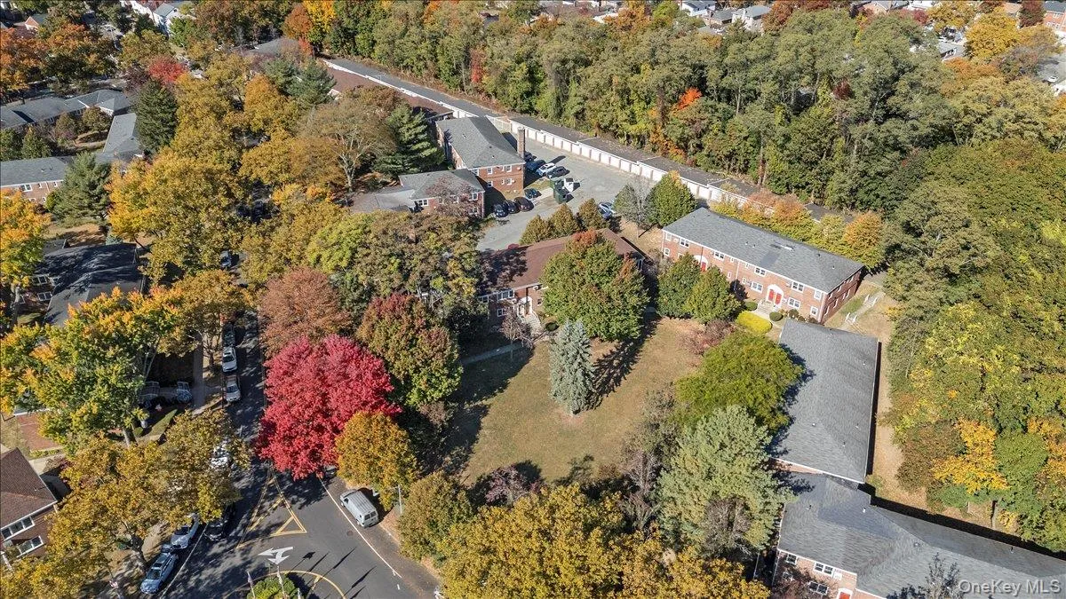 Expansive property featuring multiple brick buildings with gray roofs, surrounded by mature trees with autumnal foliage Expansive property featuring multiple brick buildings with gray roofs, surrounded by mature trees with autumnal foliage