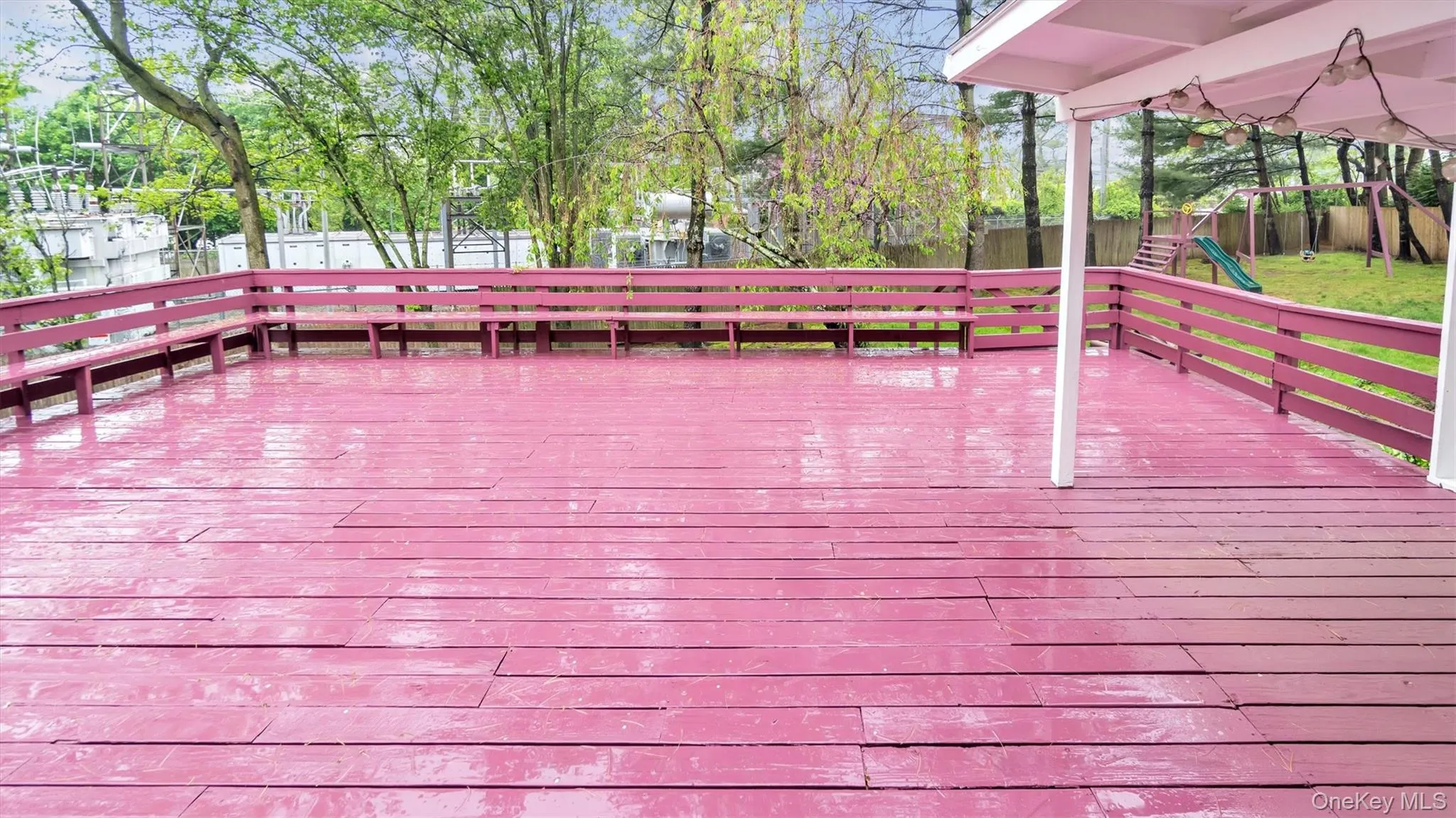 Wooden deck with playground community and a fenced backyard Wooden deck with playground community and a fenced backyard