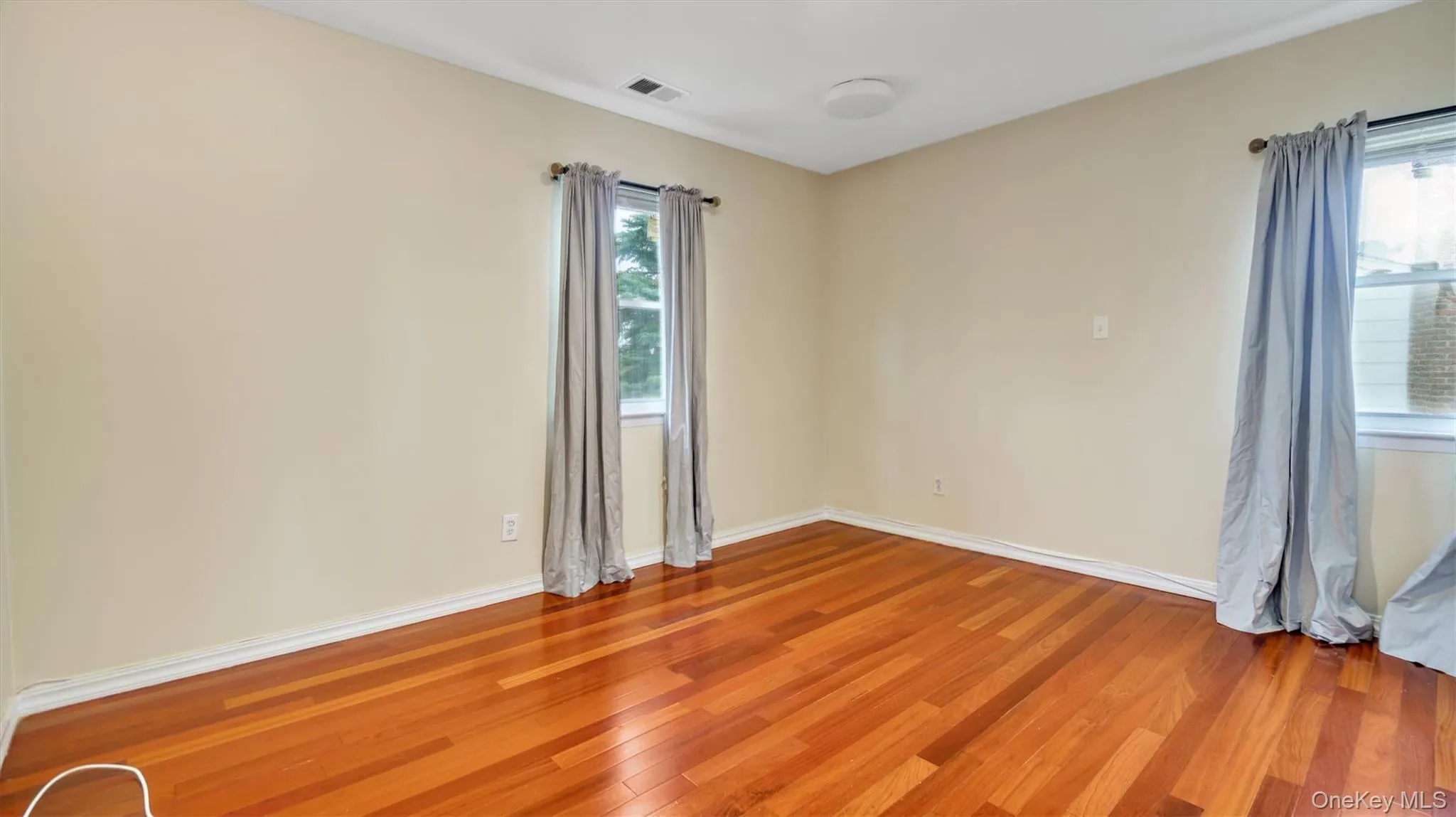 Unfurnished room with light wood-style flooring, baseboards, and visible vents Unfurnished room with light wood-style flooring, baseboards, and visible vents