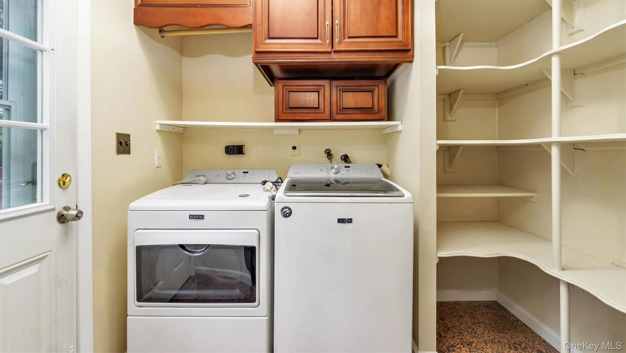 Washroom with washing machine and clothes dryer, cabinet space, and baseboards Washroom with washing machine and clothes dryer, cabinet space, and baseboards
