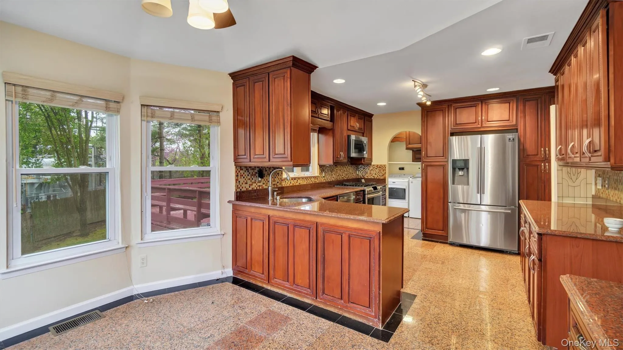 Kitchen with stainless steel appliances, granite finish floor, visible vents, and a sink Kitchen with stainless steel appliances, granite finish floor, visible vents, and a sink