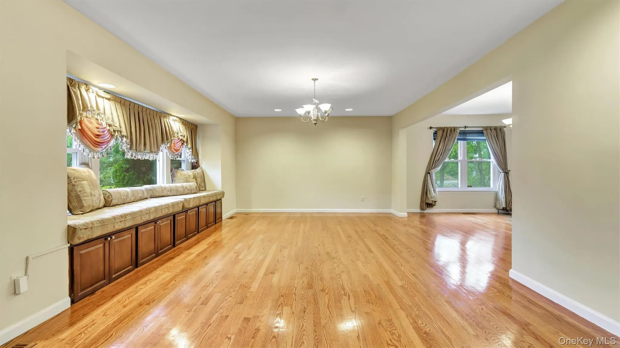 Unfurnished living room featuring light wood finished floors, a chandelier, baseboards, and recessed lighting Unfurnished living room featuring light wood finished floors, a chandelier, baseboards, and recessed lighting