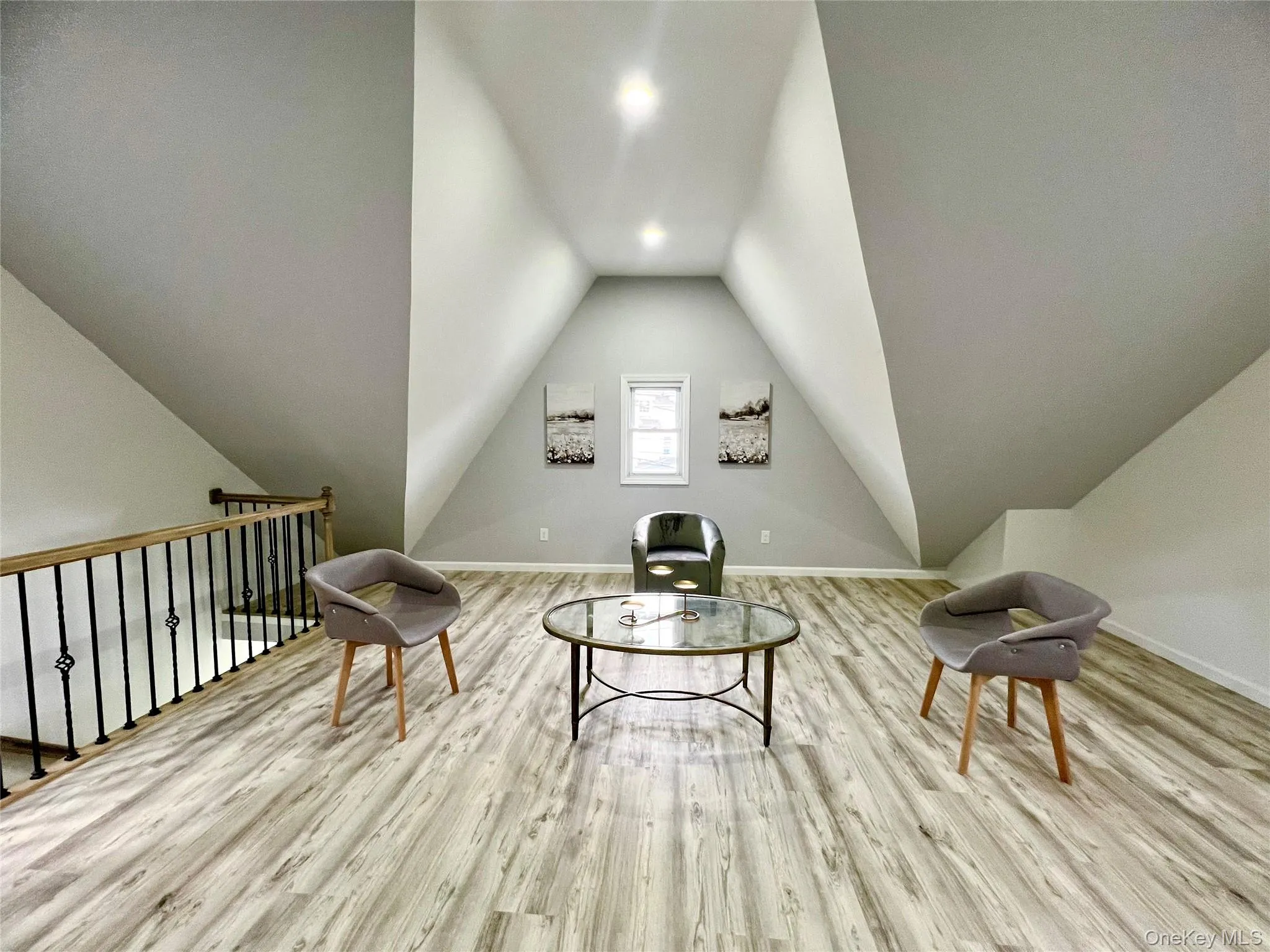 Sitting room featuring light wood-type flooring and lofted ceiling Sitting room featuring light wood-type flooring and lofted ceiling