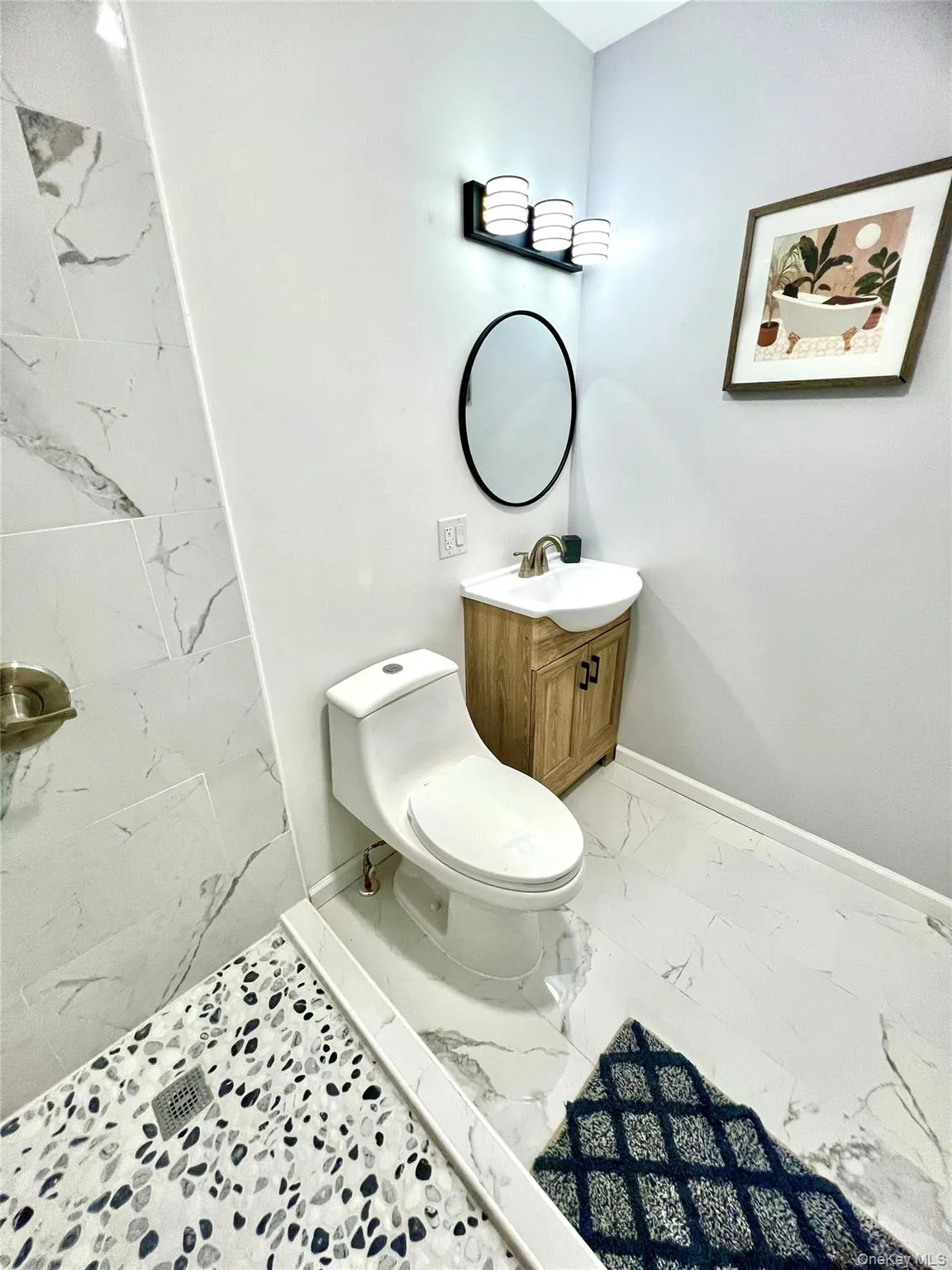 Full bath with vanity, light marble finish flooring, and a shower Full bath with vanity, light marble finish flooring, and a shower