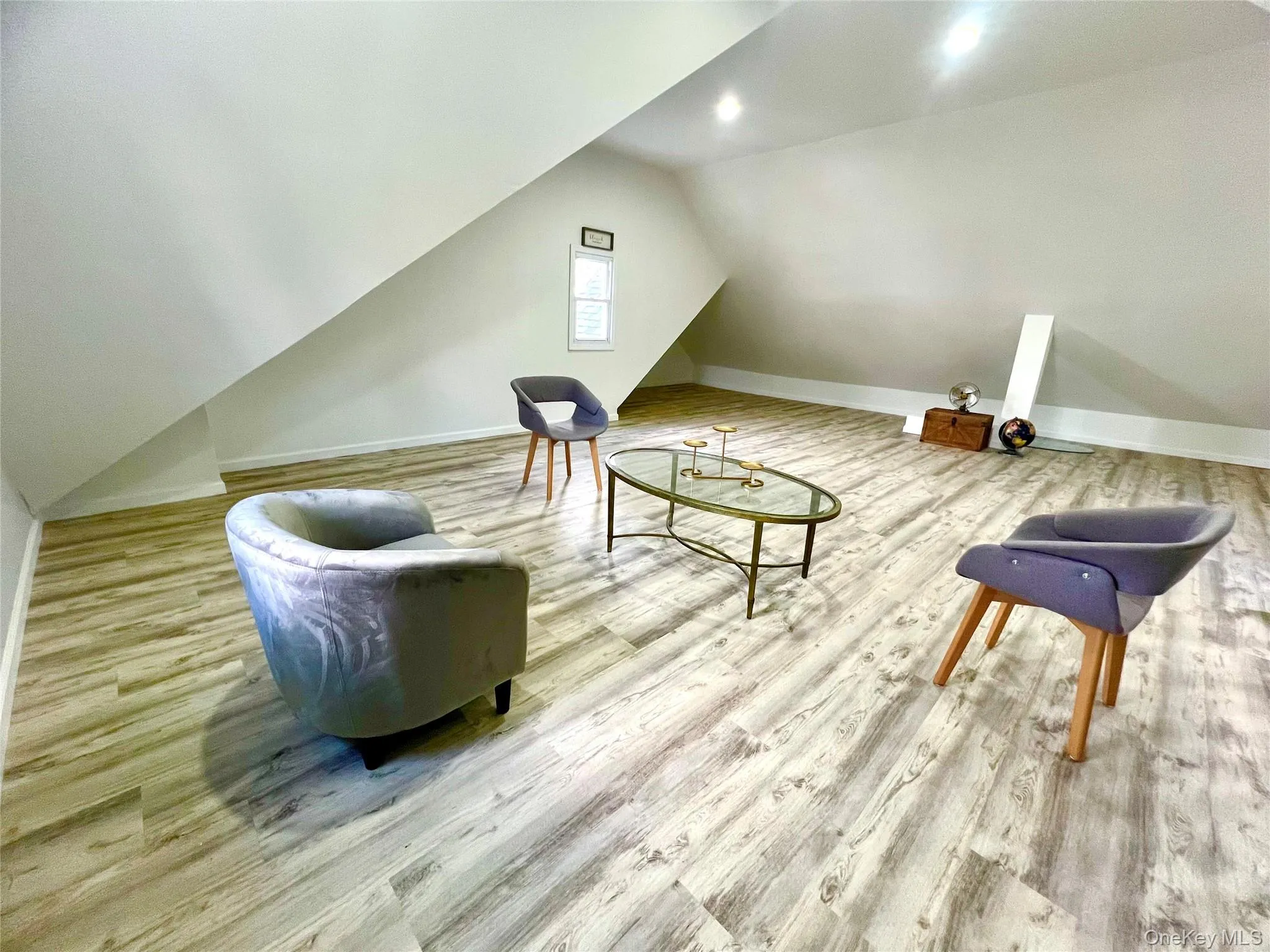 Sitting room featuring vaulted ceiling and light wood finished floors Sitting room featuring vaulted ceiling and light wood finished floors