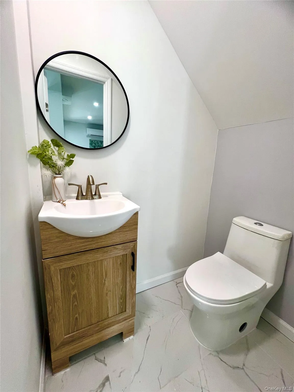 Half bath featuring light marble finish flooring and vanity Half bath featuring light marble finish flooring and vanity