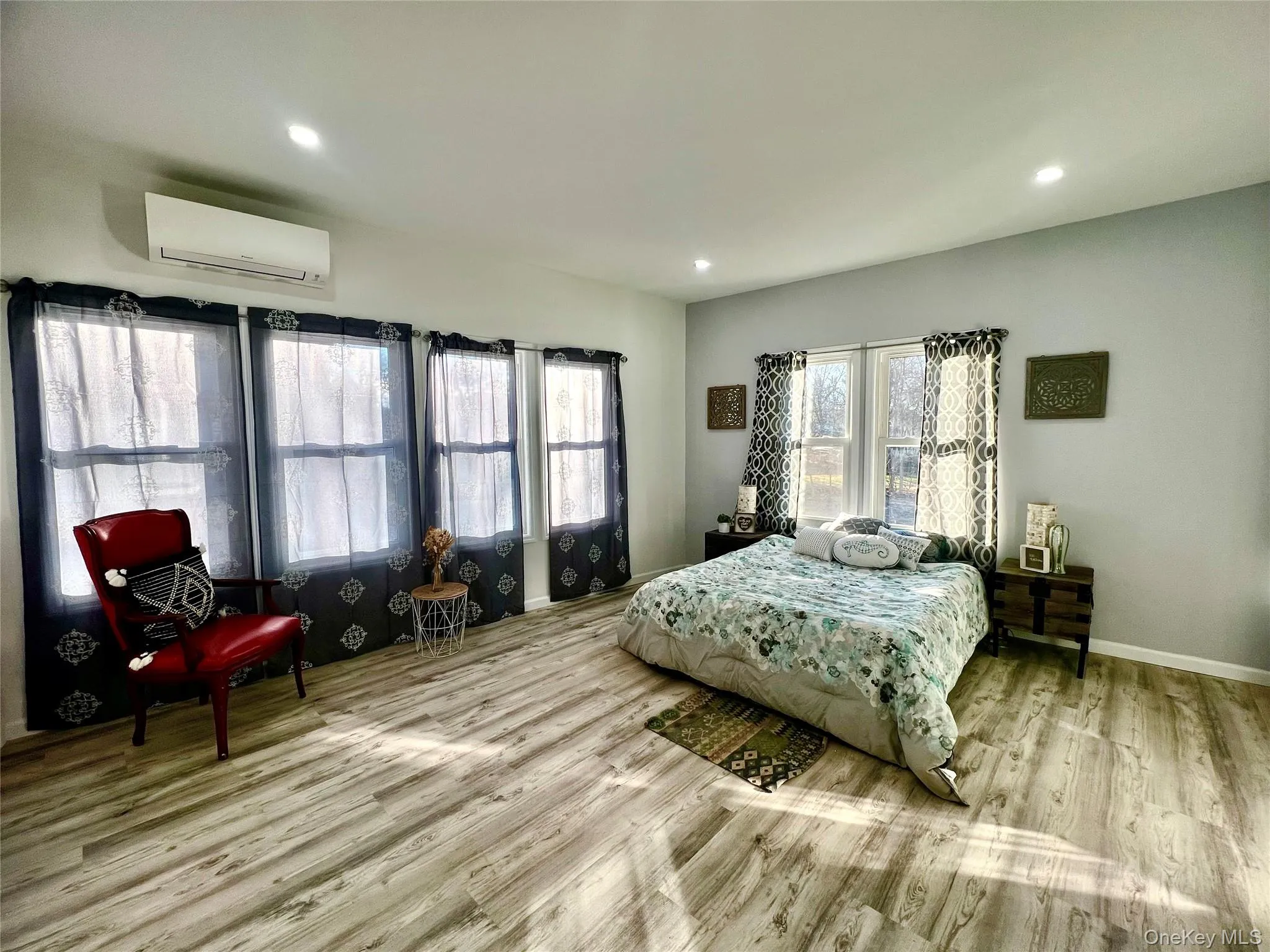 Bedroom featuring wood finished floors, an AC wall unit, and recessed lighting Bedroom featuring wood finished floors, an AC wall unit, and recessed lighting