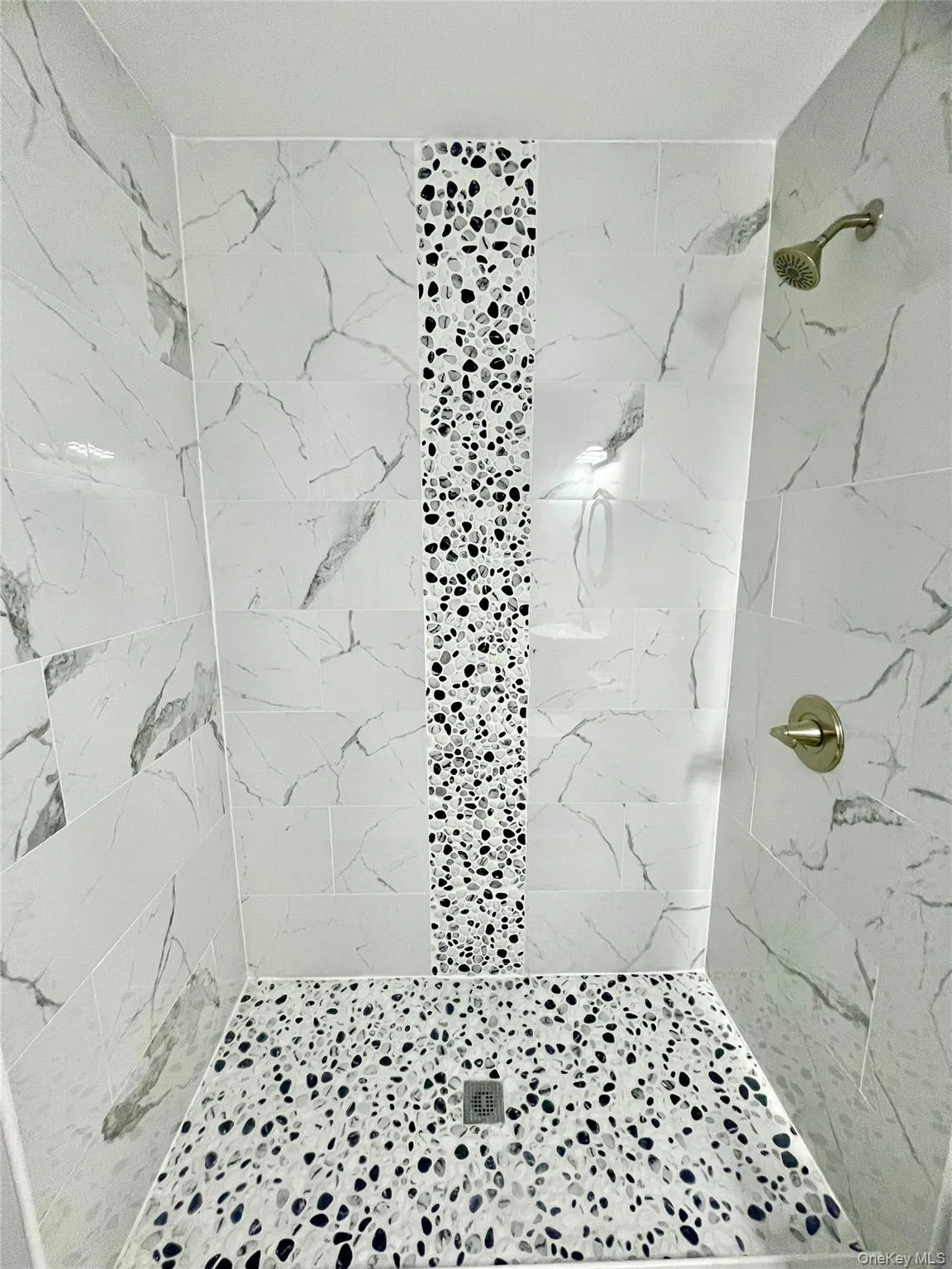 Full bath featuring a marble finish shower Full bath featuring a marble finish shower