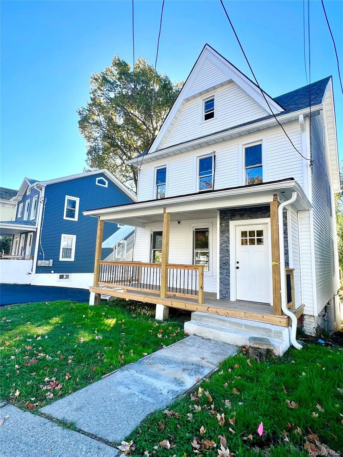 View of front of house featuring covered porch, a front yard, and stone siding View of front of house featuring covered porch, a front yard, and stone siding