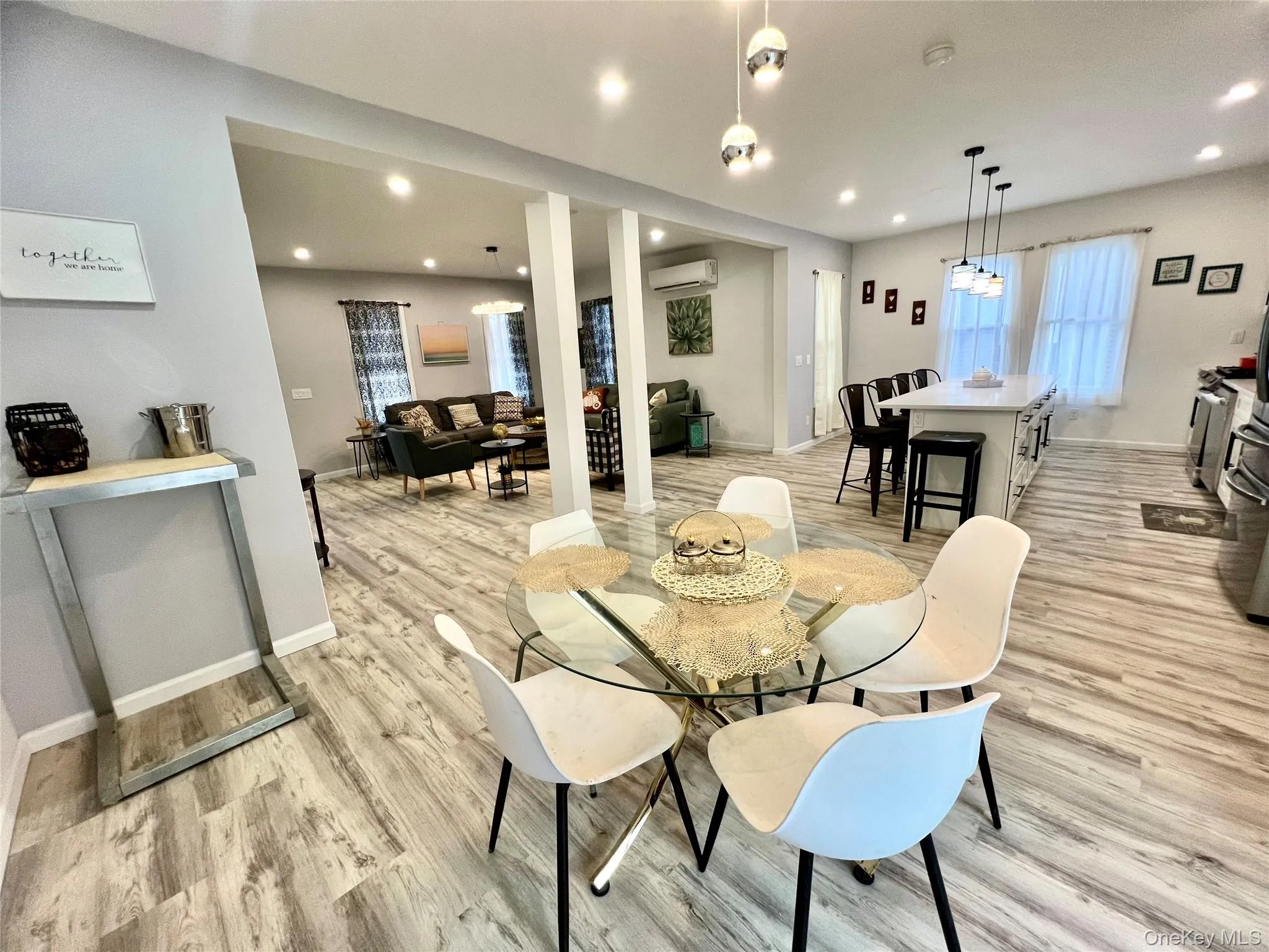 Dining space with light wood-type flooring, recessed lighting, and a wall mounted AC Dining space with light wood-type flooring, recessed lighting, and a wall mounted AC