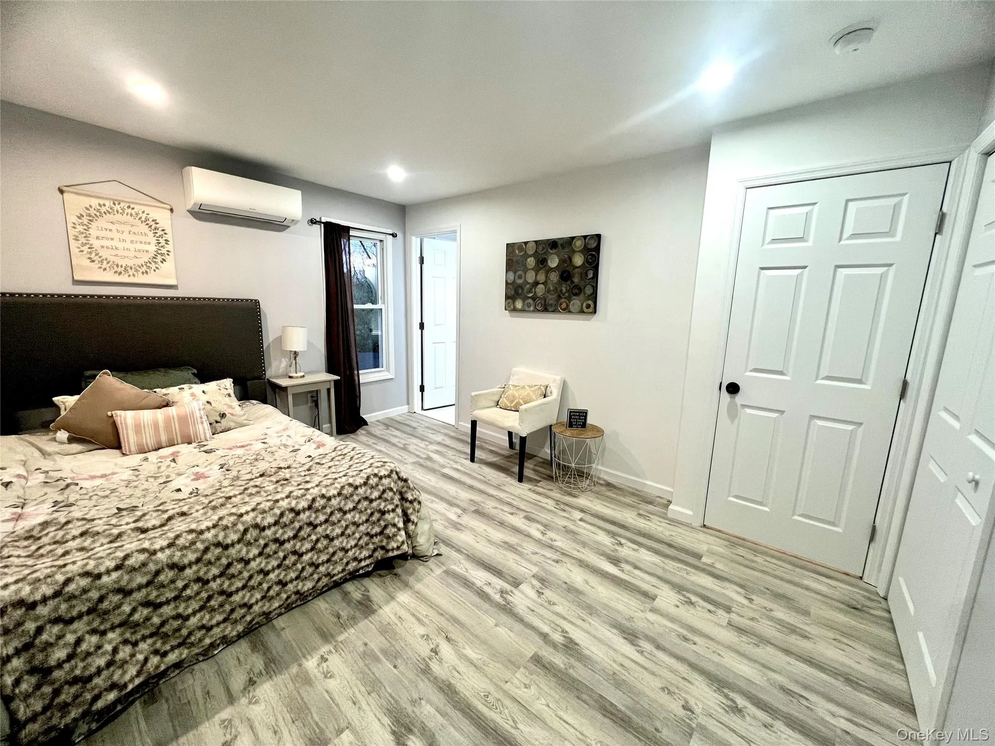 Bedroom featuring light wood-type flooring, recessed lighting, and a wall unit AC Bedroom featuring light wood-type flooring, recessed lighting, and a wall unit AC