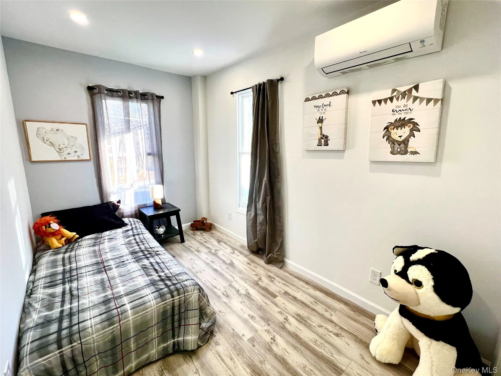 Bedroom with a wall mounted air conditioner, wood finished floors, and recessed lighting Bedroom with a wall mounted air conditioner, wood finished floors, and recessed lighting