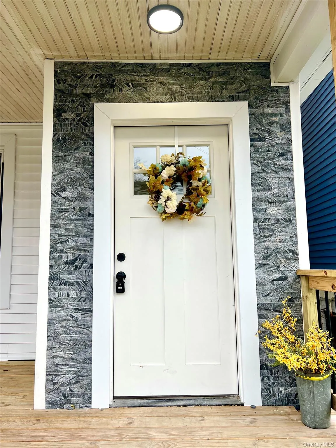 View of exterior entry featuring stone siding and a deck View of exterior entry featuring stone siding and a deck