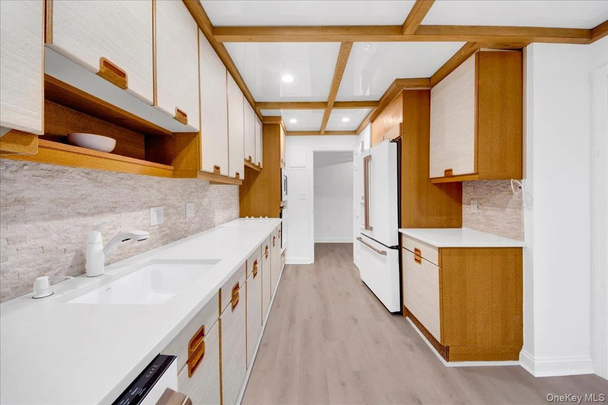 Kitchen with recessed lighting, light wood finished floors, high end fridge, decorative backsplash, and wood finish cabinets Kitchen with recessed lighting, light wood finished floors, high end fridge, decorative backsplash, and wood finish cabinets