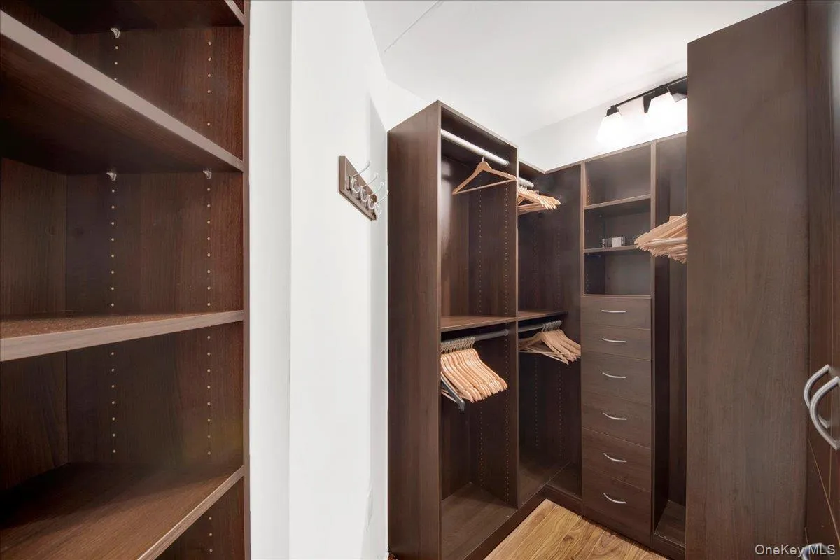 California Walk in closet with light wood-style flooring California Walk in closet with light wood-style flooring
