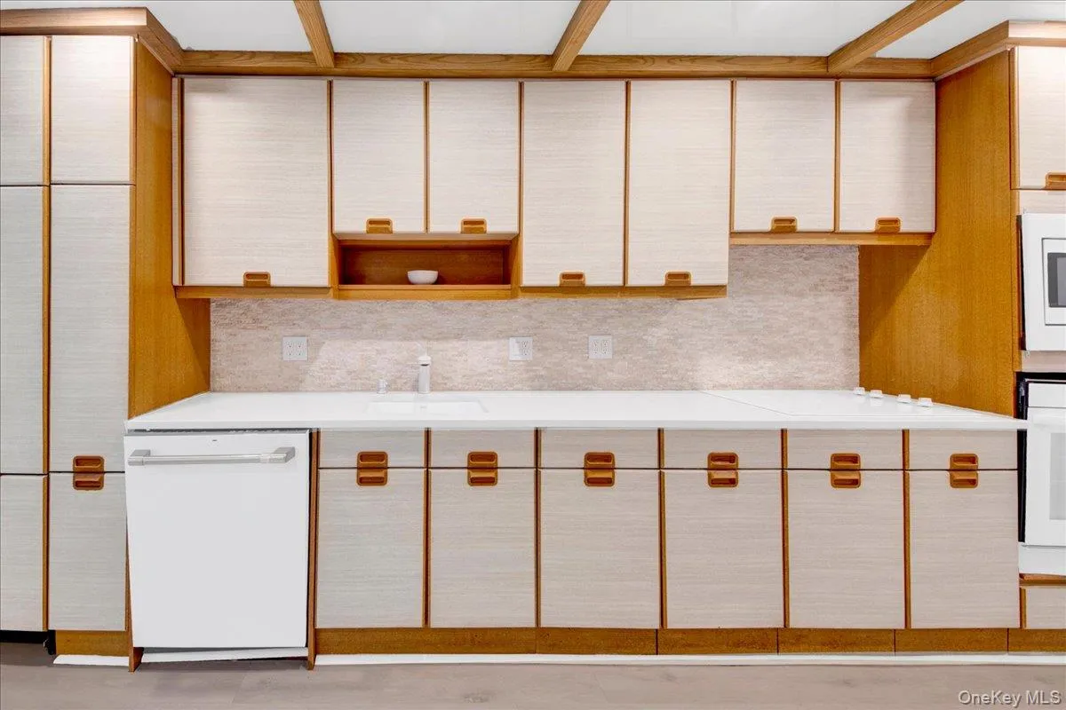 Two tone kitchen with light countertops, white stainless steel appliances, two tone cabinets, backsplash, and open shelves Two tone kitchen with light countertops, white stainless steel appliances, two tone cabinets, backsplash, and open shelves