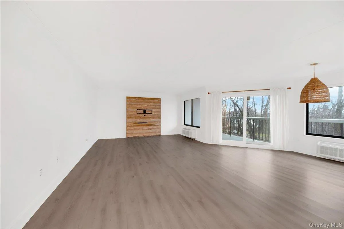 Unfurnished living room featuring dark wood-style floors Unfurnished living room featuring dark wood-style floors
