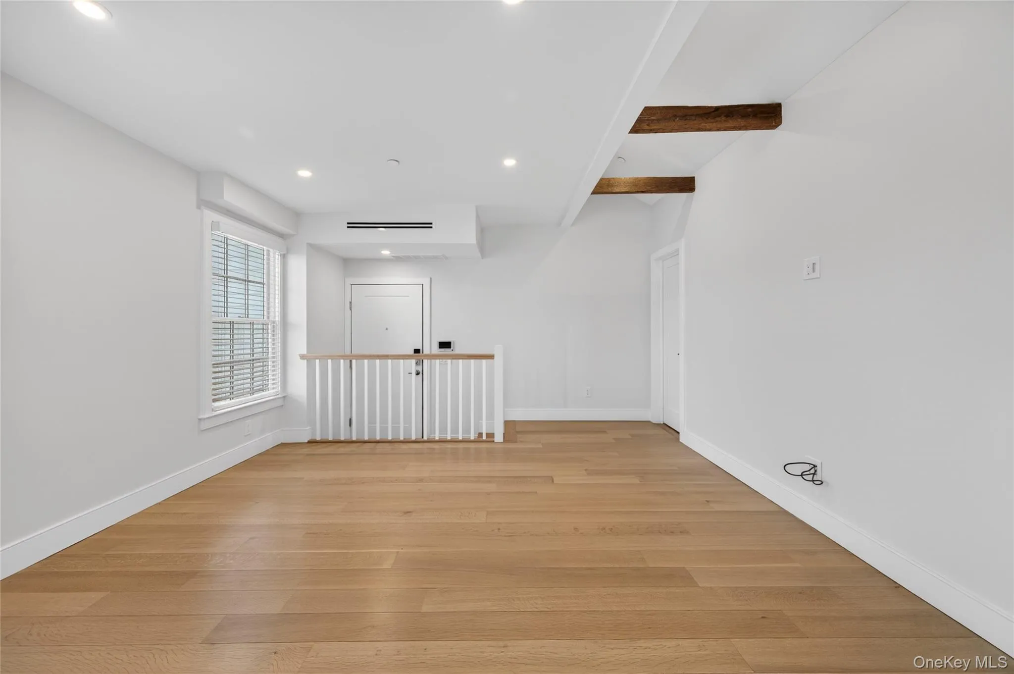 Open-concept interior featuring light wood-finish flooring and bright white walls Open-concept interior featuring light wood-finish flooring and bright white walls