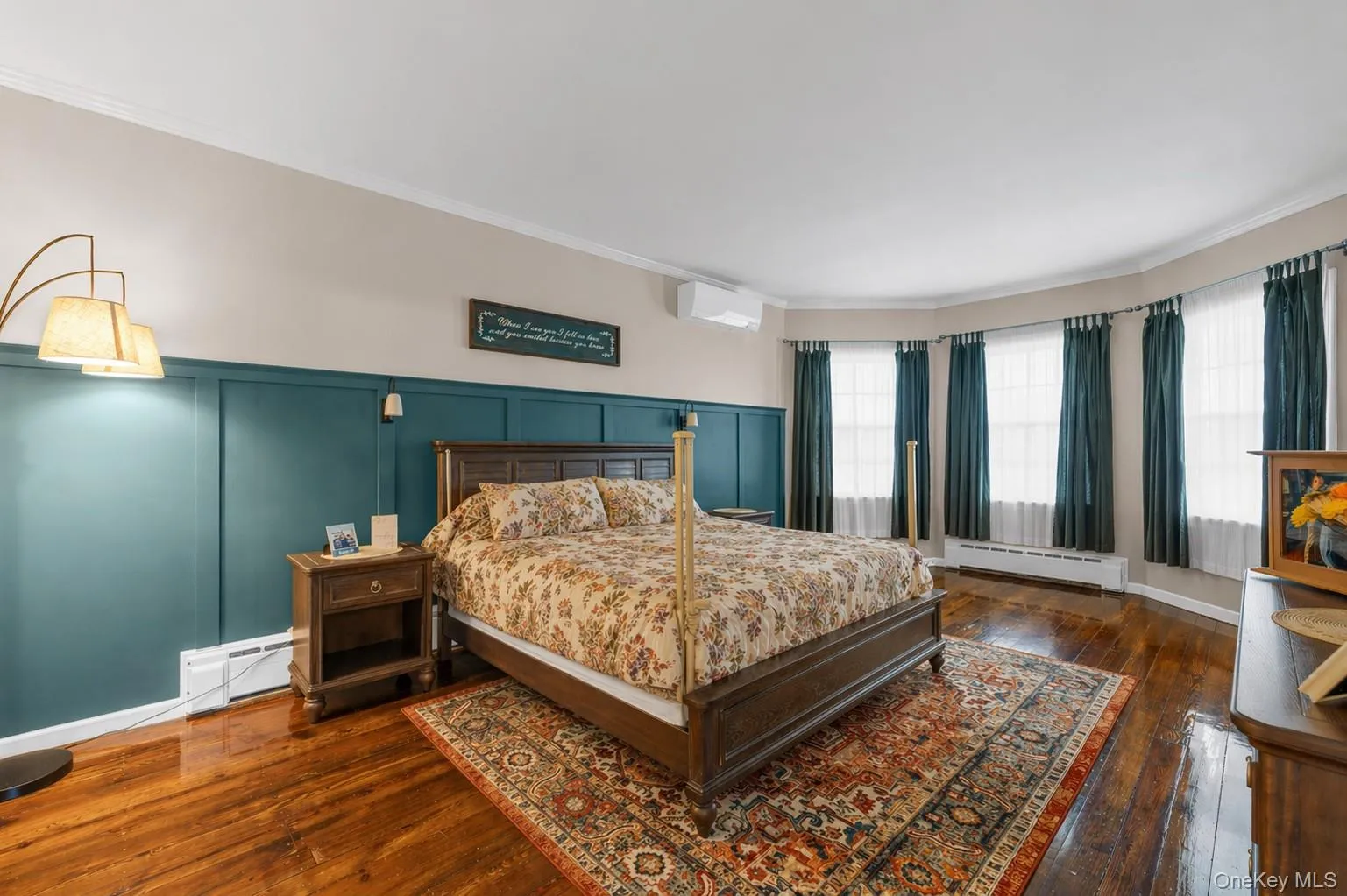 Primary bedroom with hardwood flooring, crown molding, 9 foot ceilings and an en-suite bathroom Primary bedroom with hardwood flooring, crown molding, 9 foot ceilings and an en-suite bathroom