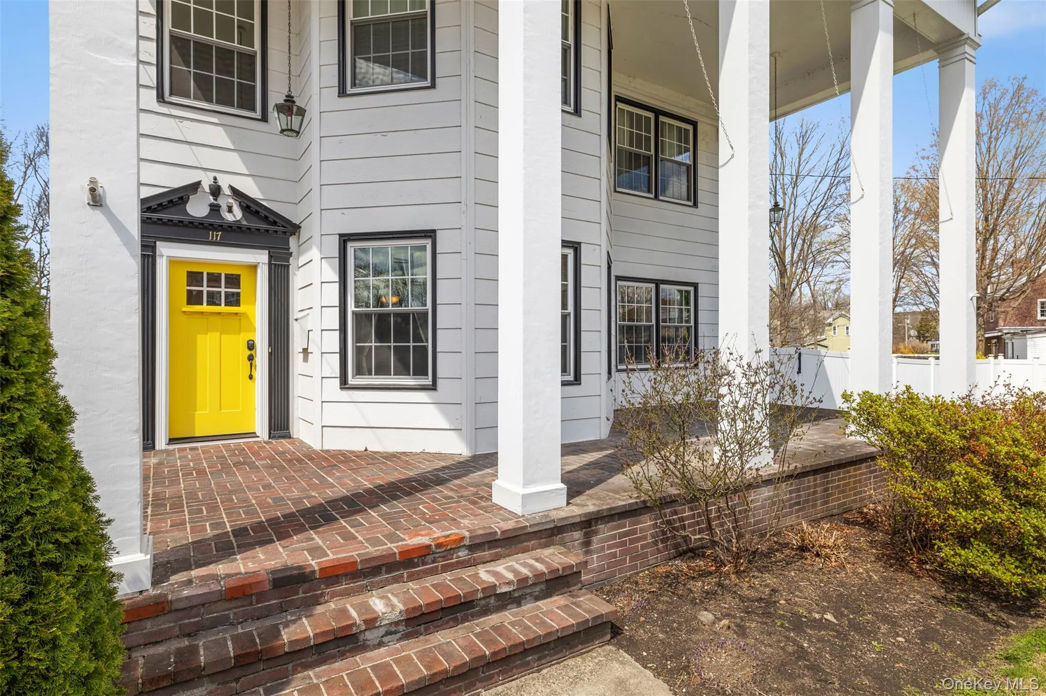 Front of home featuring grand columns, brick porch and welcoming front door Front of home featuring grand columns, brick porch and welcoming front door