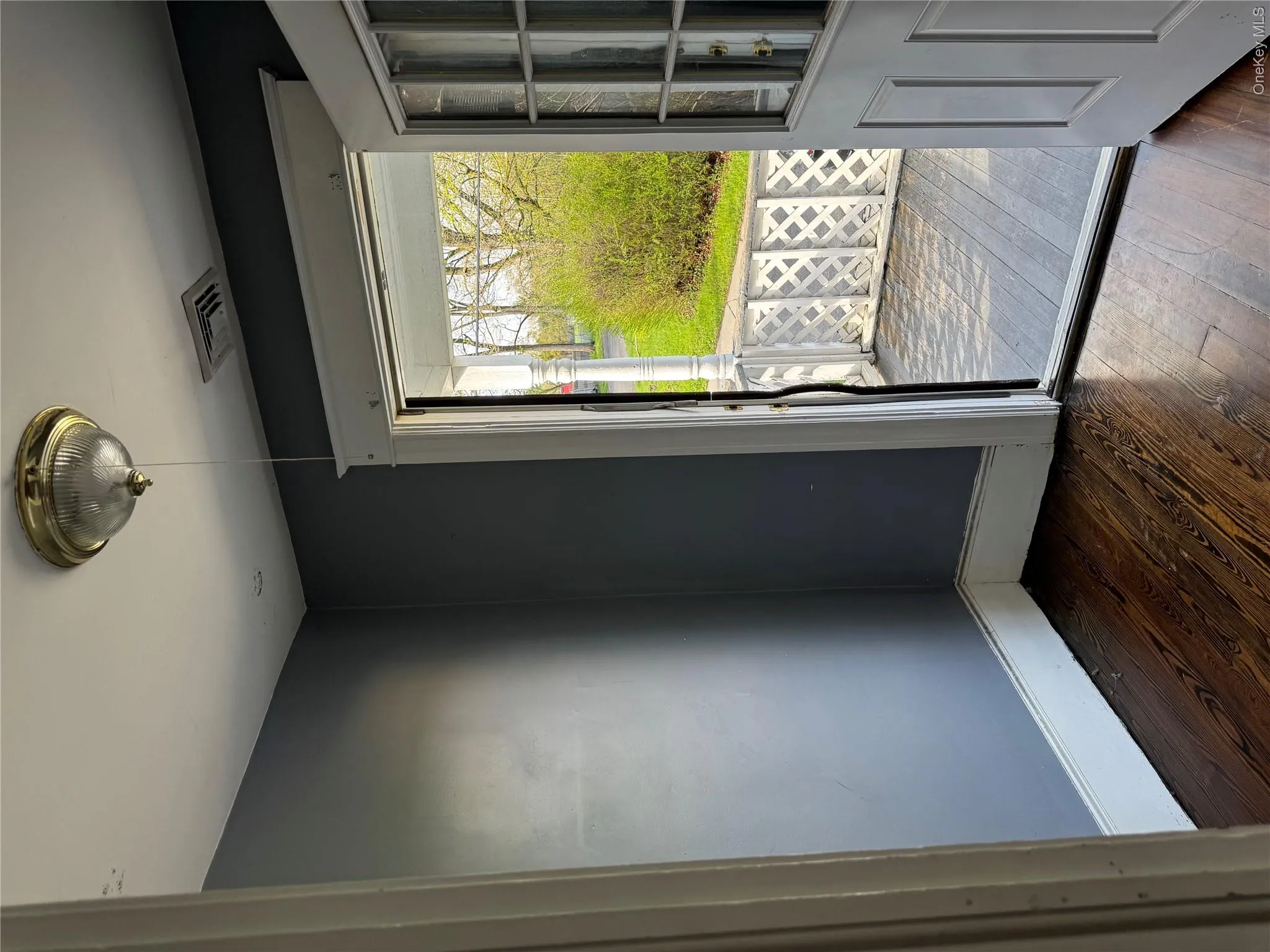 Interior entry with dark wood-finish flooring, deep blue-gray wall paint, and white trim Interior entry with dark wood-finish flooring, deep blue-gray wall paint, and white trim