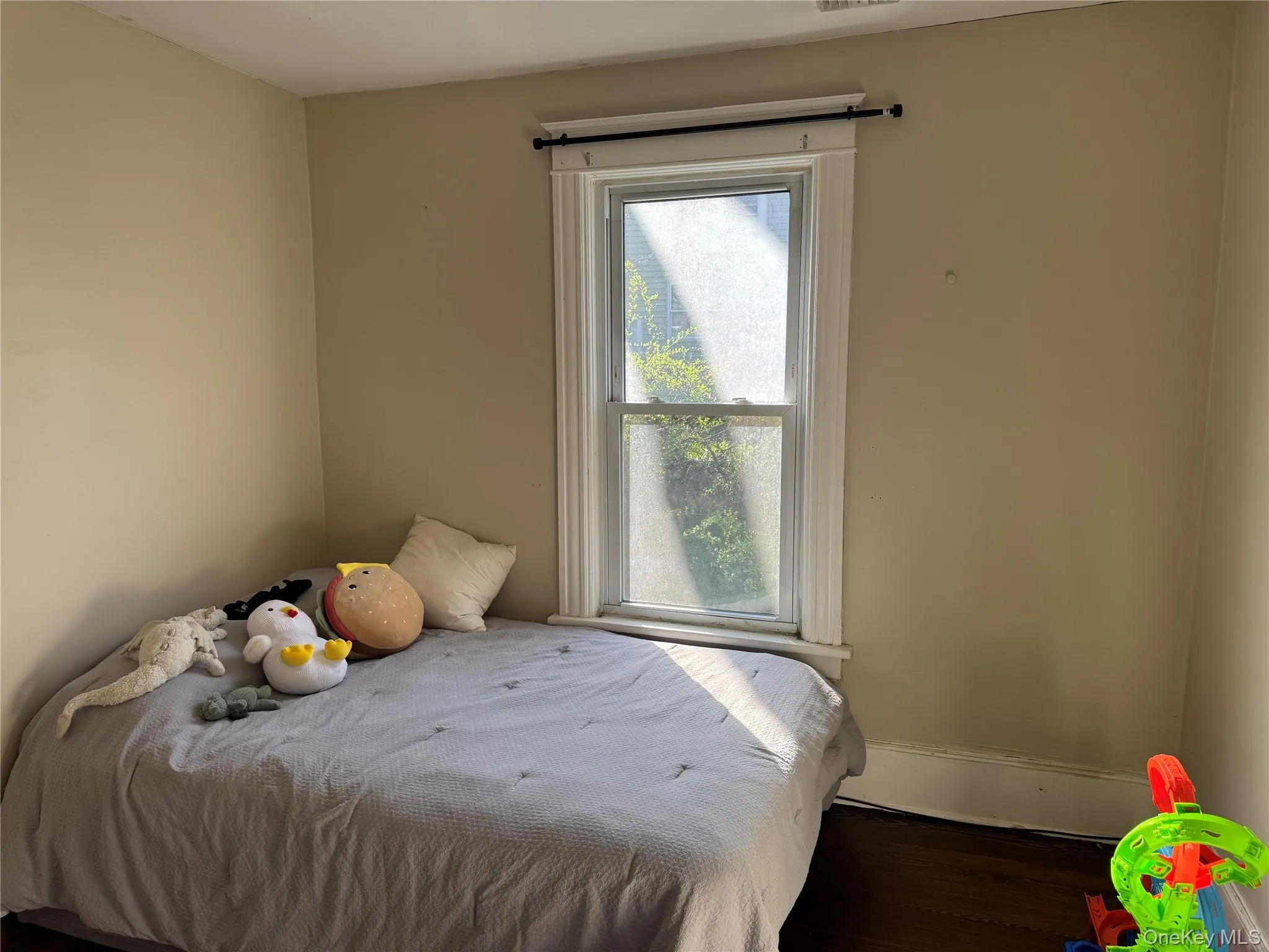 Room with a single window featuring white trim and a dark curtain rod Room with a single window featuring white trim and a dark curtain rod