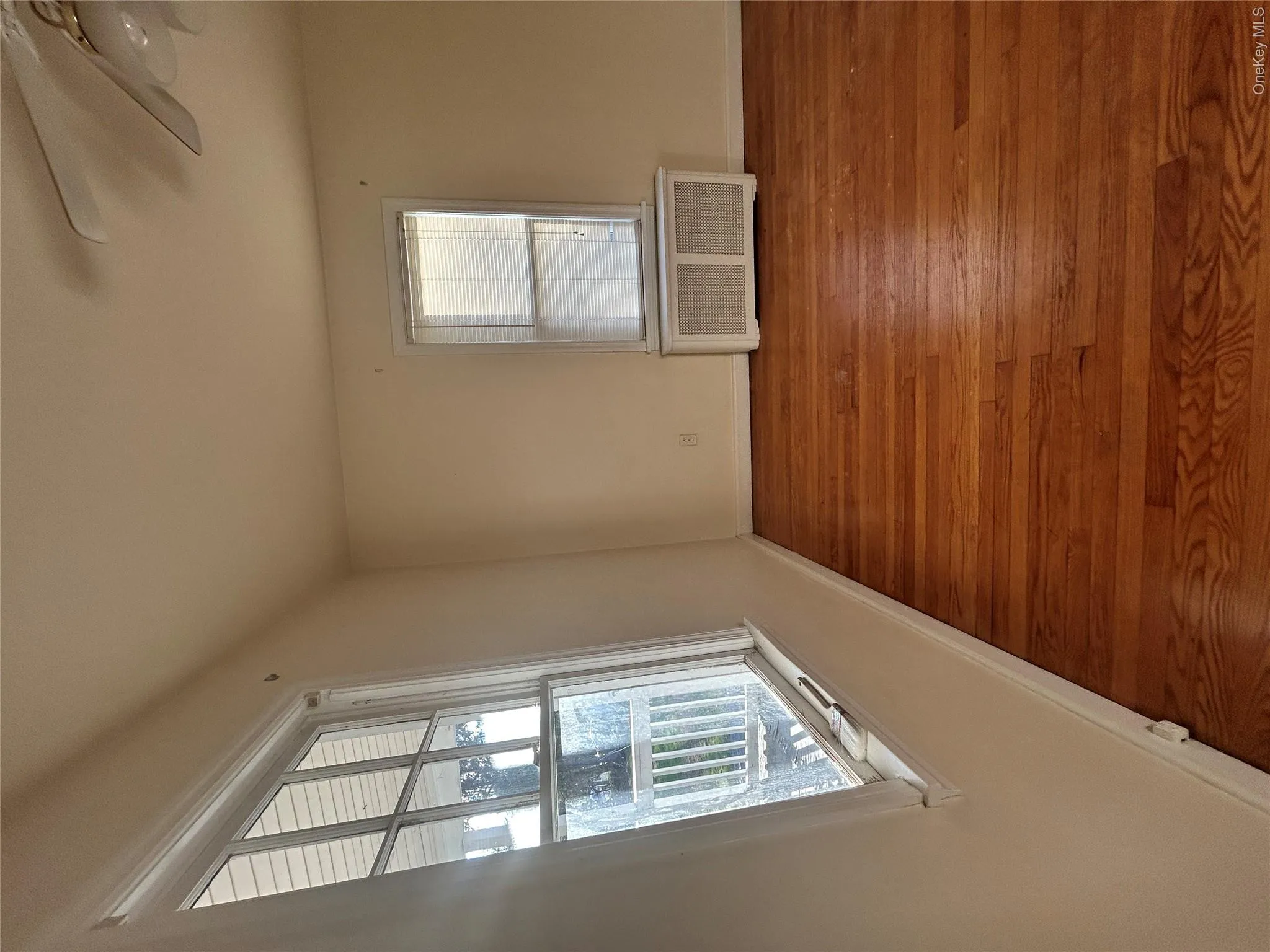 Spare room with radiator heating unit, wood finished floors, and a ceiling fan Spare room with radiator heating unit, wood finished floors, and a ceiling fan