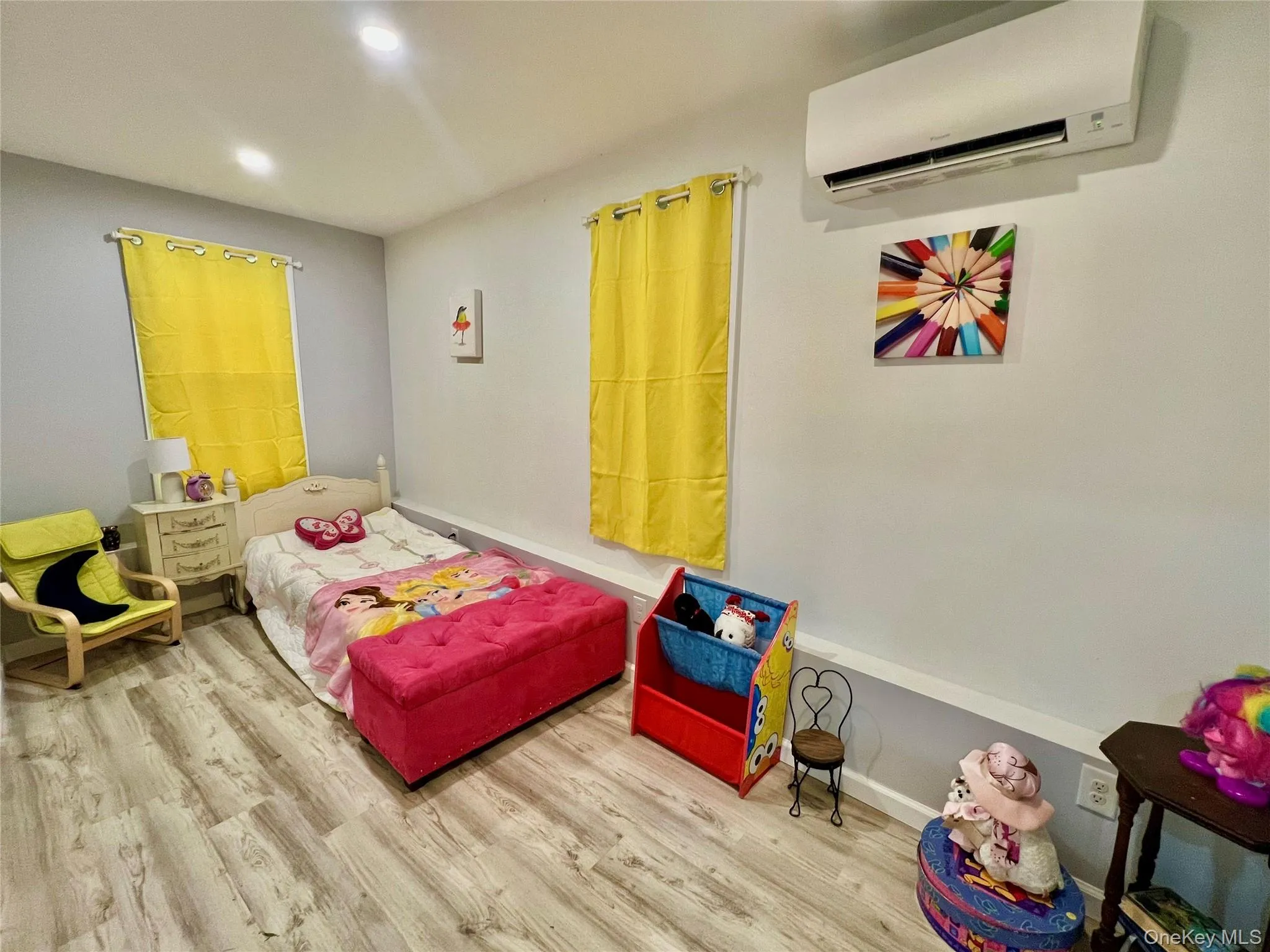 Bedroom featuring a wall unit AC, wood finished floors, and recessed lighting Bedroom featuring a wall unit AC, wood finished floors, and recessed lighting