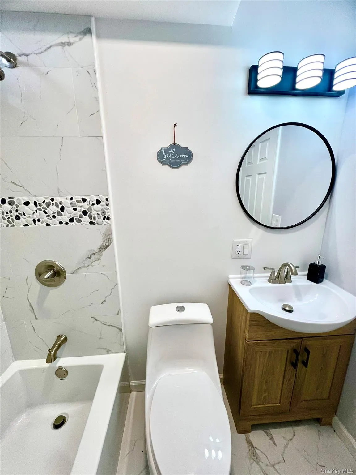 Bathroom featuring vanity, light marble finish flooring, and tub / shower combination Bathroom featuring vanity, light marble finish flooring, and tub / shower combination