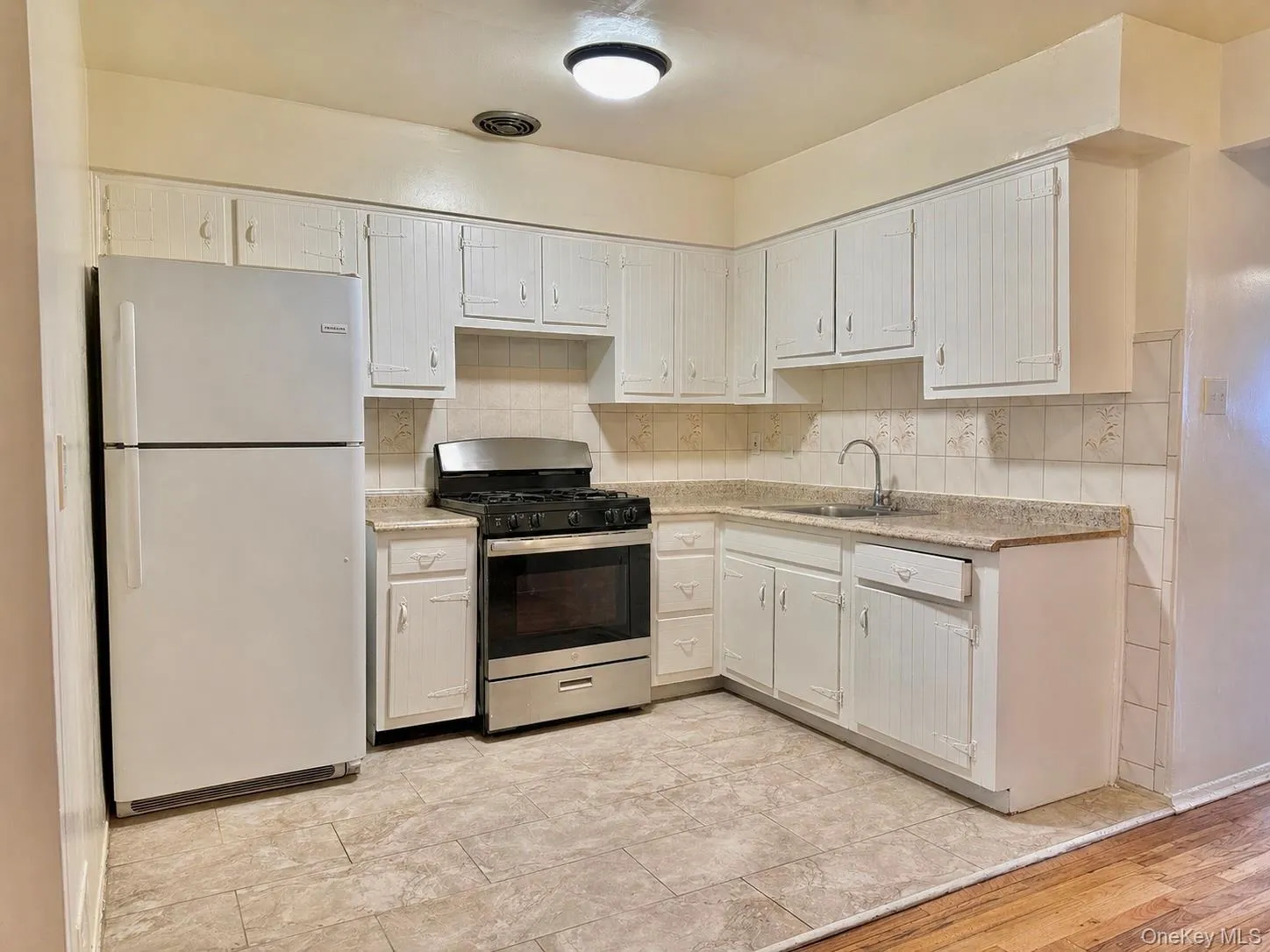Kitchen featuring white cabinetry, light-toned countertops, a stainless steel range, and tile flooring Kitchen featuring white cabinetry, light-toned countertops, a stainless steel range, and tile flooring