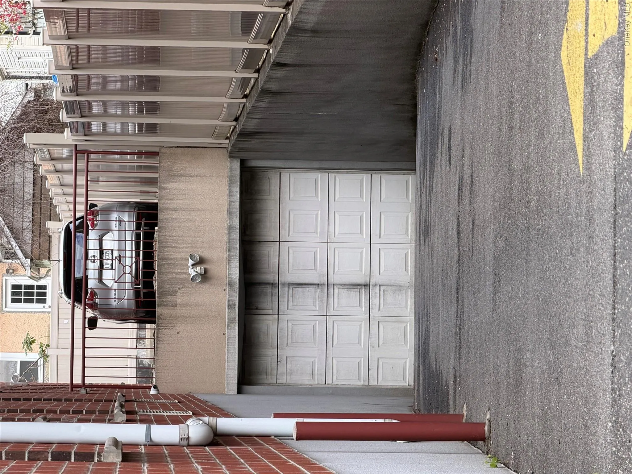 Integral garage with a panel door, concrete driveway, and brick wall exterior Integral garage with a panel door, concrete driveway, and brick wall exterior