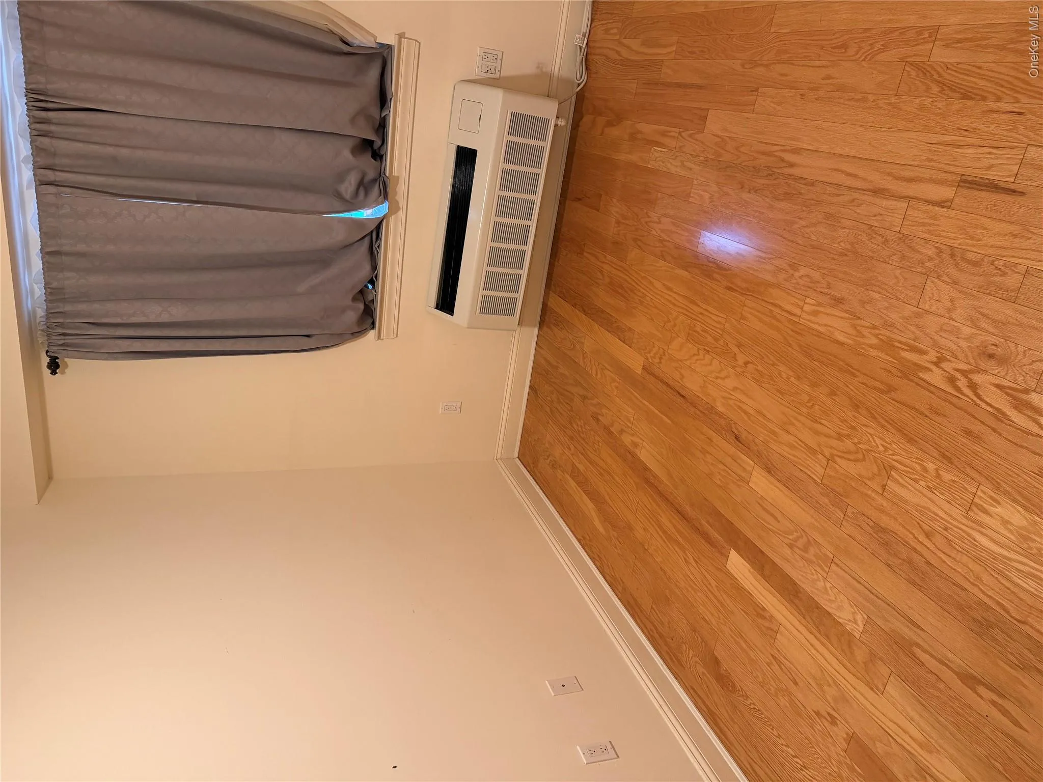 Hardwood-style flooring throughout, complemented by a window-mounted air conditioning unit Hardwood-style flooring throughout, complemented by a window-mounted air conditioning unit