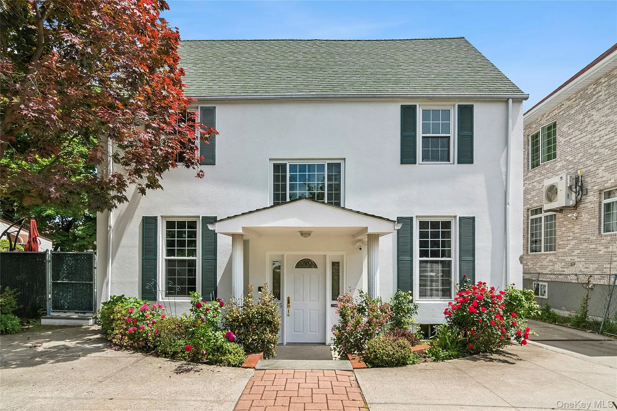 White stucco exterior with a green shingle roof White stucco exterior with a green shingle roof