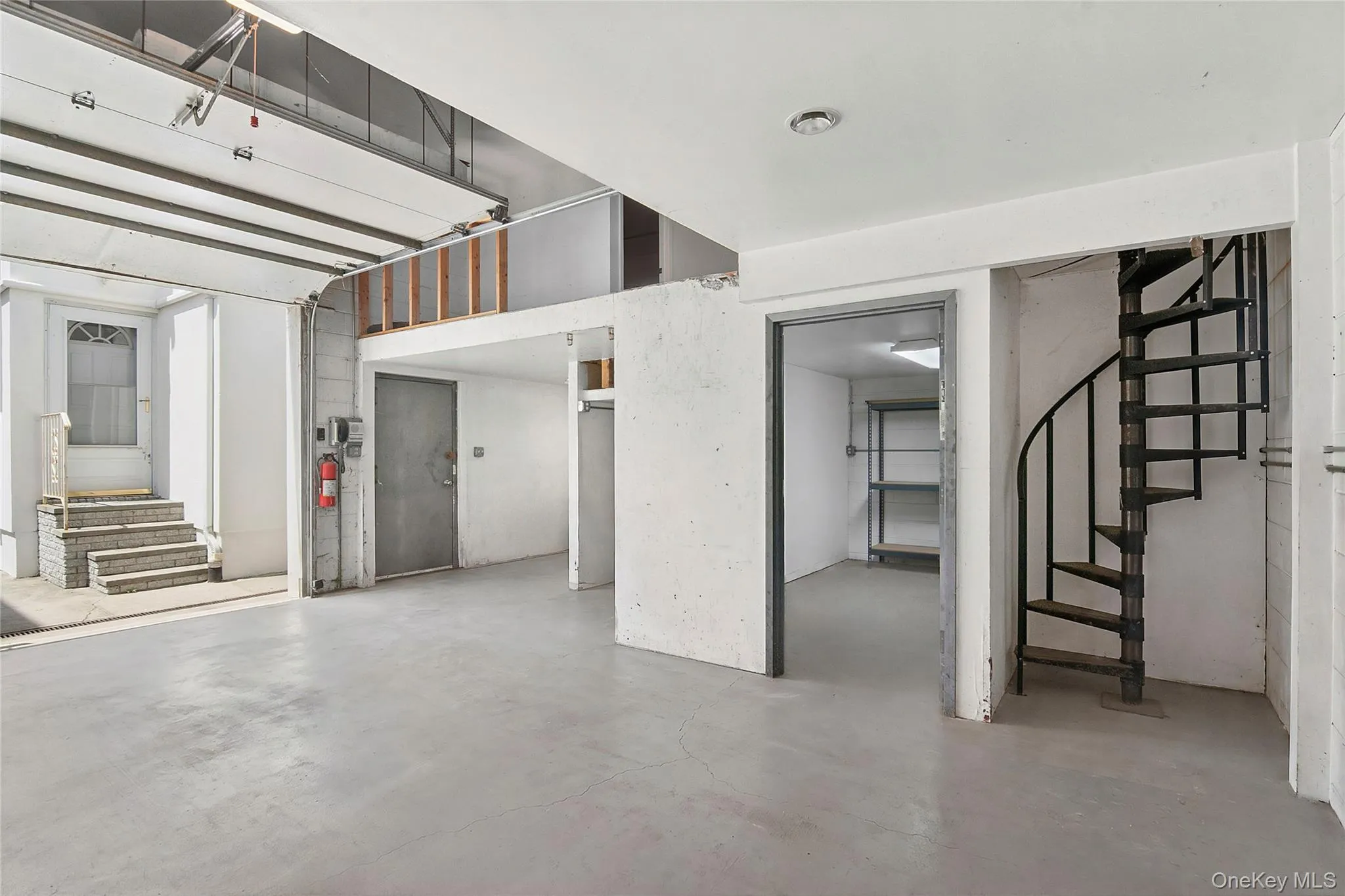 Garage interior featuring multiple storage rooms, stairs to loft area Garage interior featuring multiple storage rooms, stairs to loft area