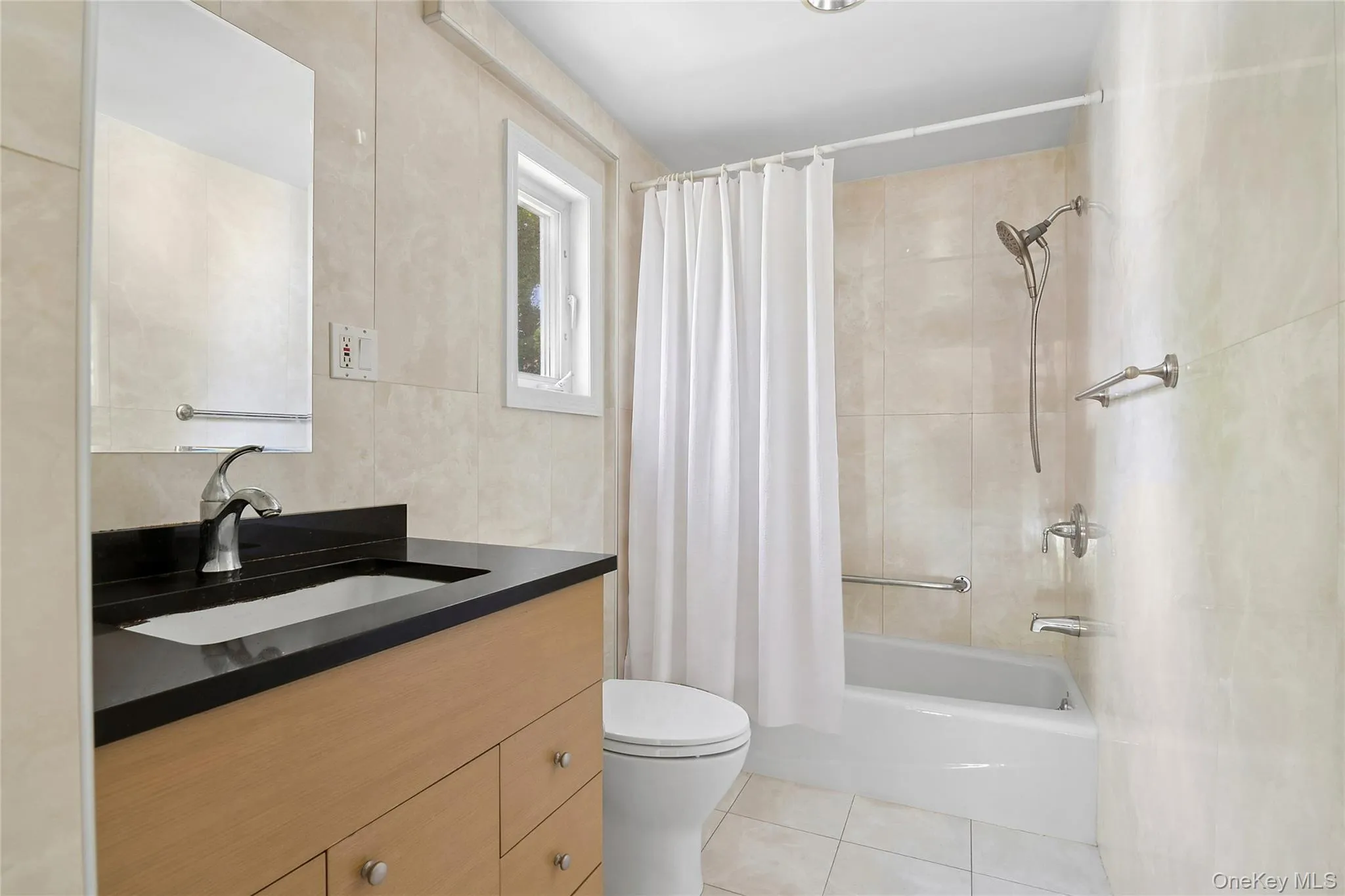 Second Floor Hall Bathroom featuring a light wood-finish vanity with a black countertop, undermount sink, and brushed nickel fixtures Second Floor Hall Bathroom featuring a light wood-finish vanity with a black countertop, undermount sink, and brushed nickel fixtures