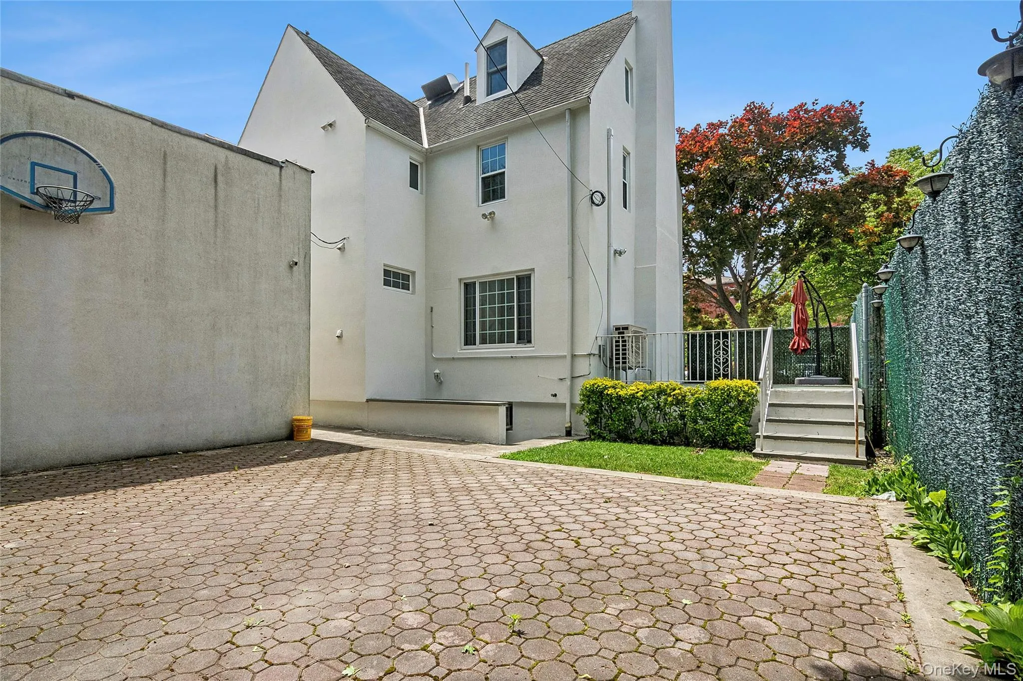 Paved outdoor area, view of detached garage and elevated side patio Paved outdoor area, view of detached garage and elevated side patio