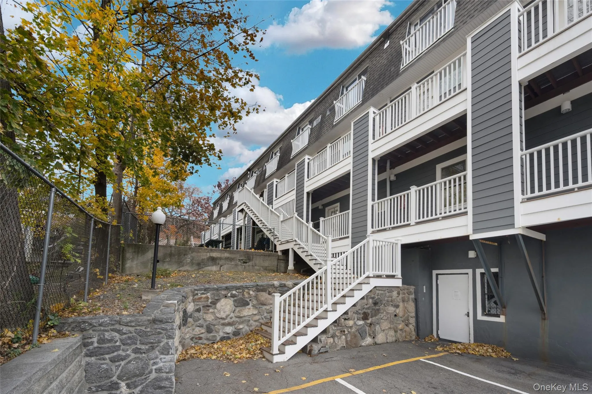 View of apartment building / complex with stairway and uncovered parking View of apartment building / complex with stairway and uncovered parking