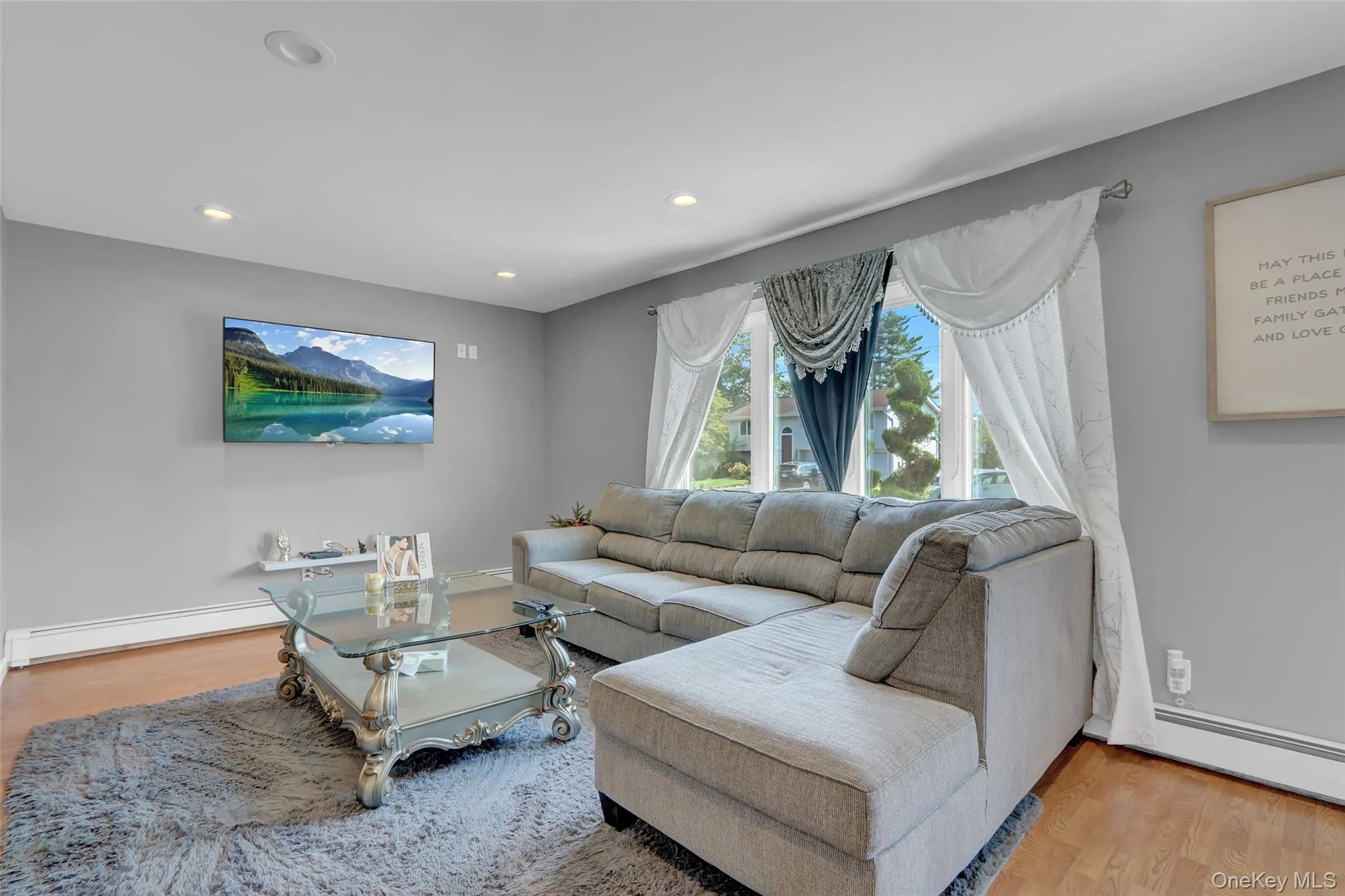 Living area featuring light gray wall paint and wood-finish flooring Living area featuring light gray wall paint and wood-finish flooring