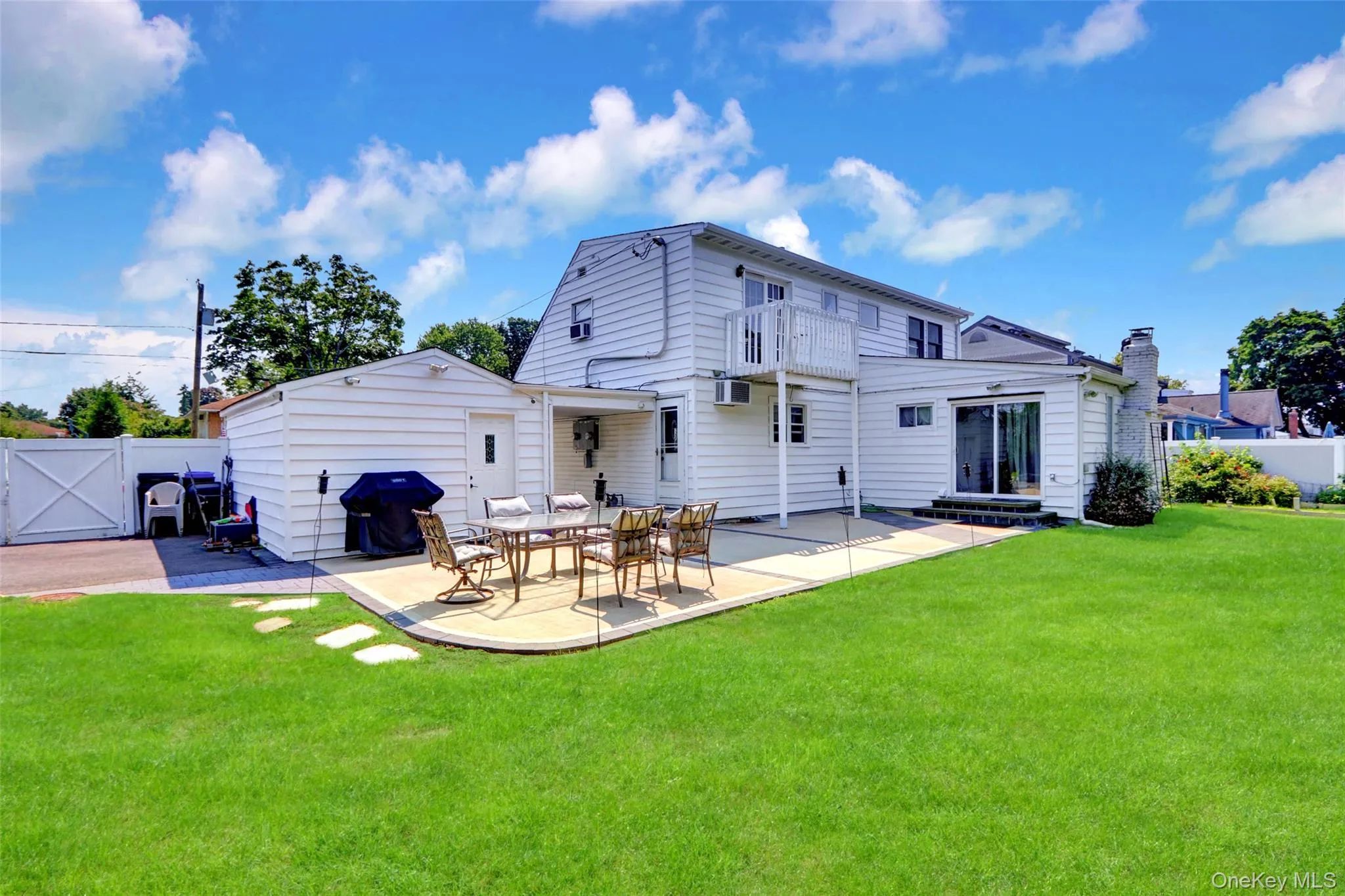 Expansive green lawn with a curved concrete patio, providing an outdoor living space Expansive green lawn with a curved concrete patio, providing an outdoor living space