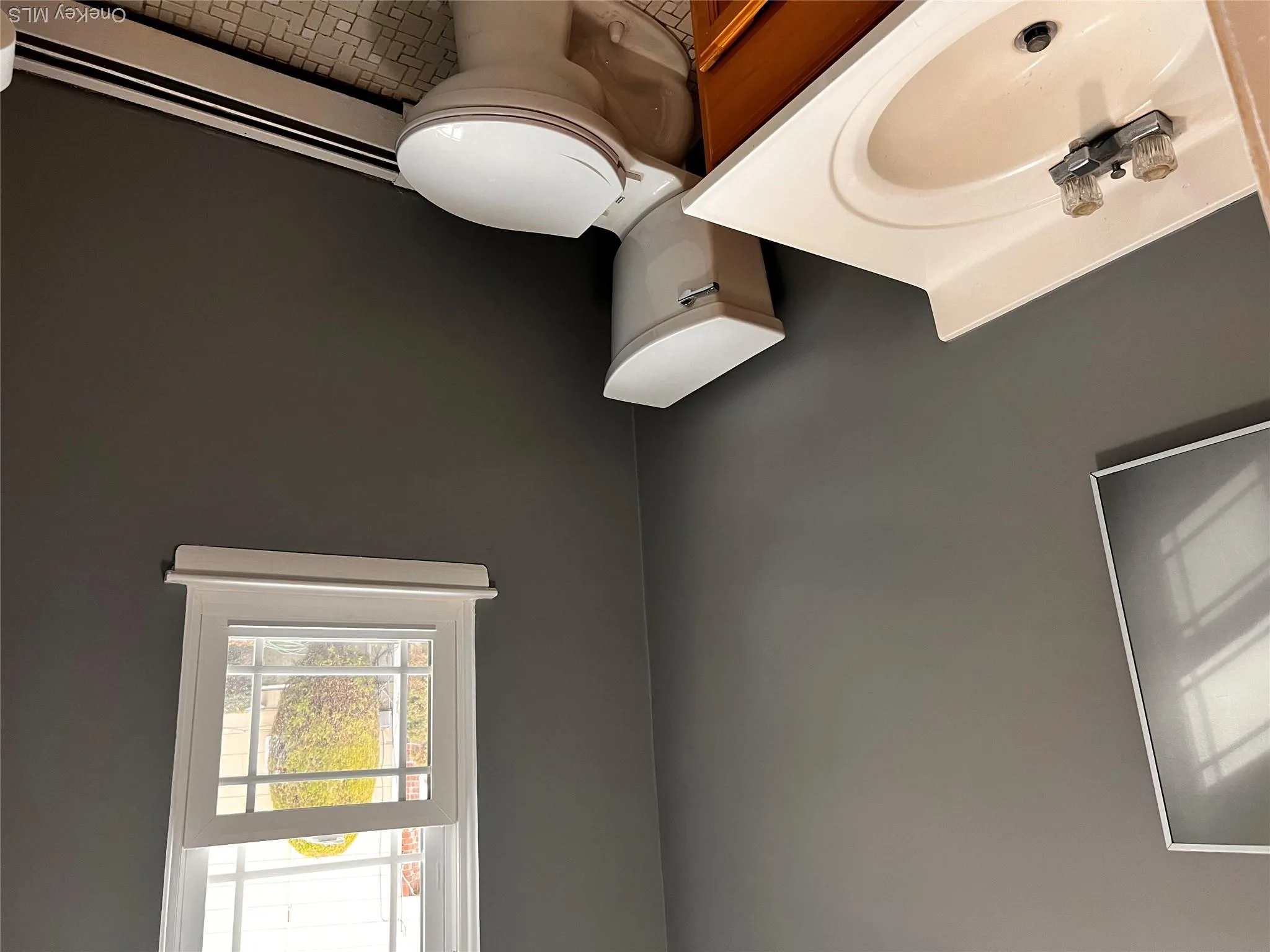 Half bath featuring baseboard heating, vanity, and light tile patterned floors Half bath featuring baseboard heating, vanity, and light tile patterned floors