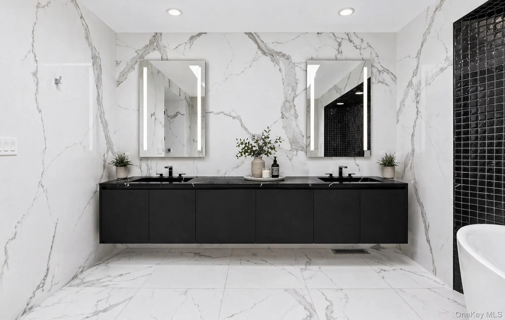 Dual floating vanity featuring a dark countertop with integrated sinks, black fixtures, and illuminated mirrors Dual floating vanity featuring a dark countertop with integrated sinks, black fixtures, and illuminated mirrors