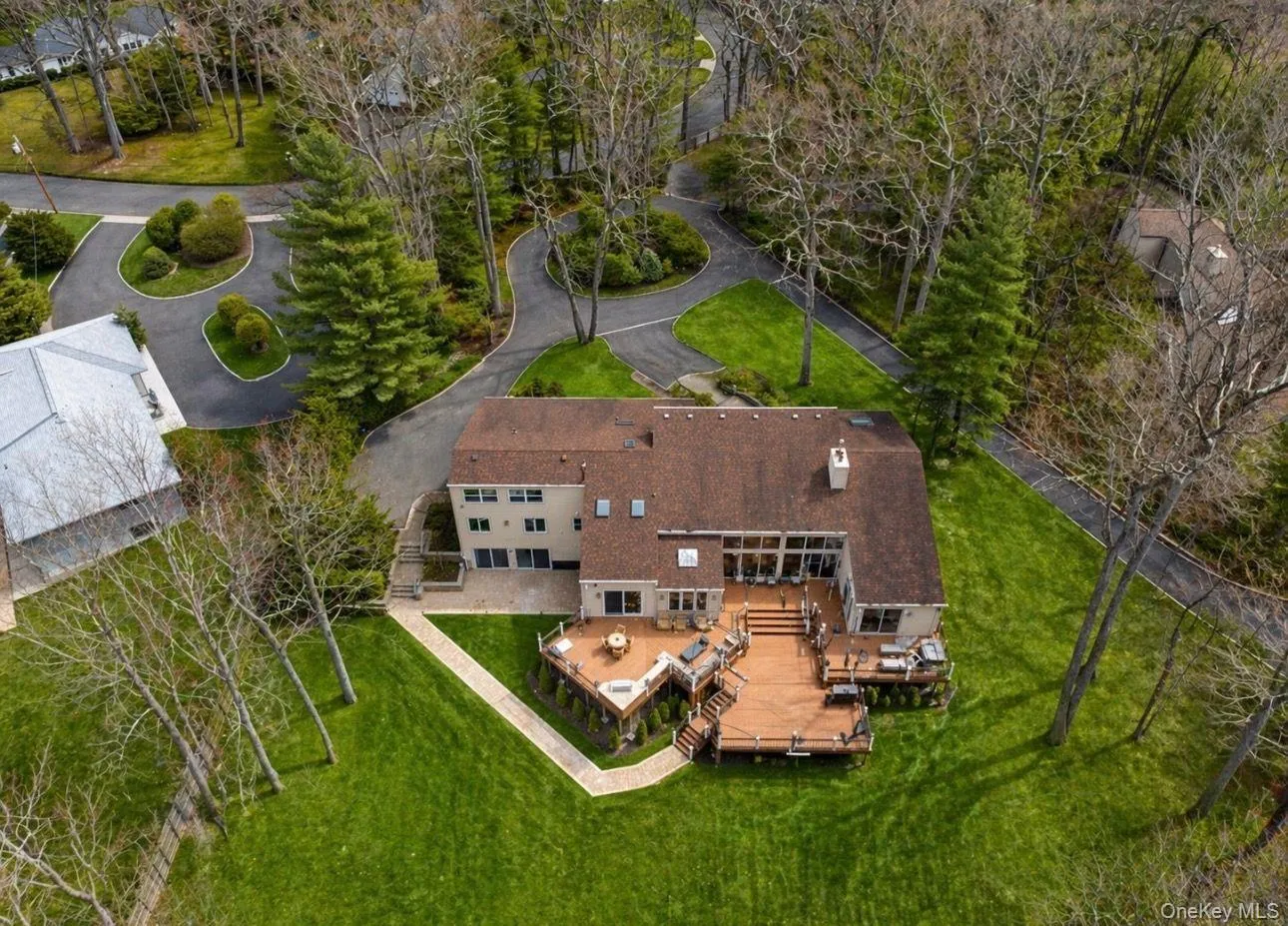 Expansive property featuring a multi-level wood deck, a patio area, and extensive green lawn Expansive property featuring a multi-level wood deck, a patio area, and extensive green lawn