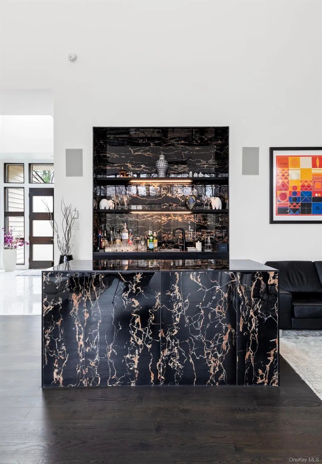 Custom bar featuring a black and gold veined stone finish, integrated shelving, and illuminated display areas Custom bar featuring a black and gold veined stone finish, integrated shelving, and illuminated display areas