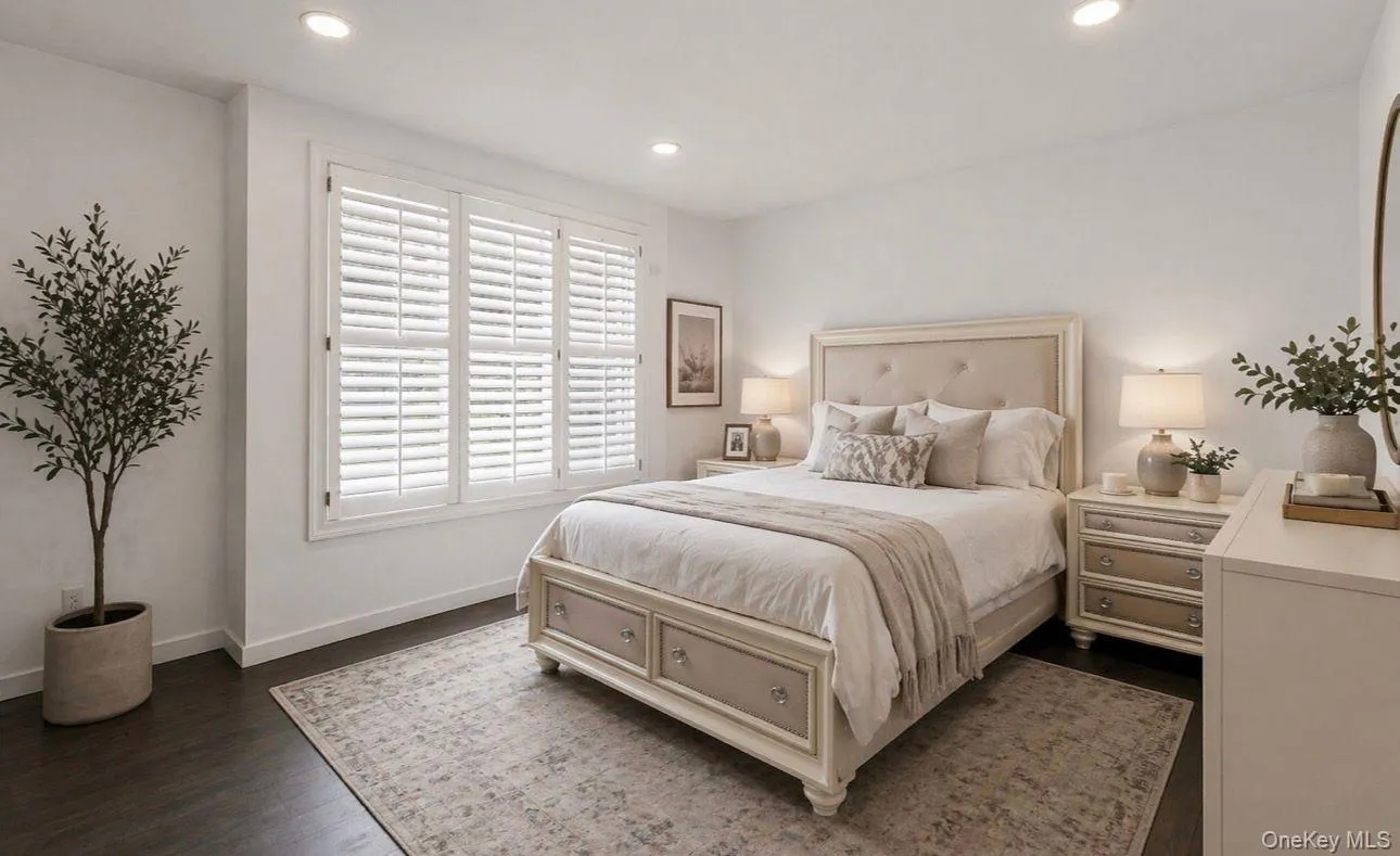 Room featuring wood-finish flooring, recessed lighting, and white plantation shutters on a multi-panel window Room featuring wood-finish flooring, recessed lighting, and white plantation shutters on a multi-panel window
