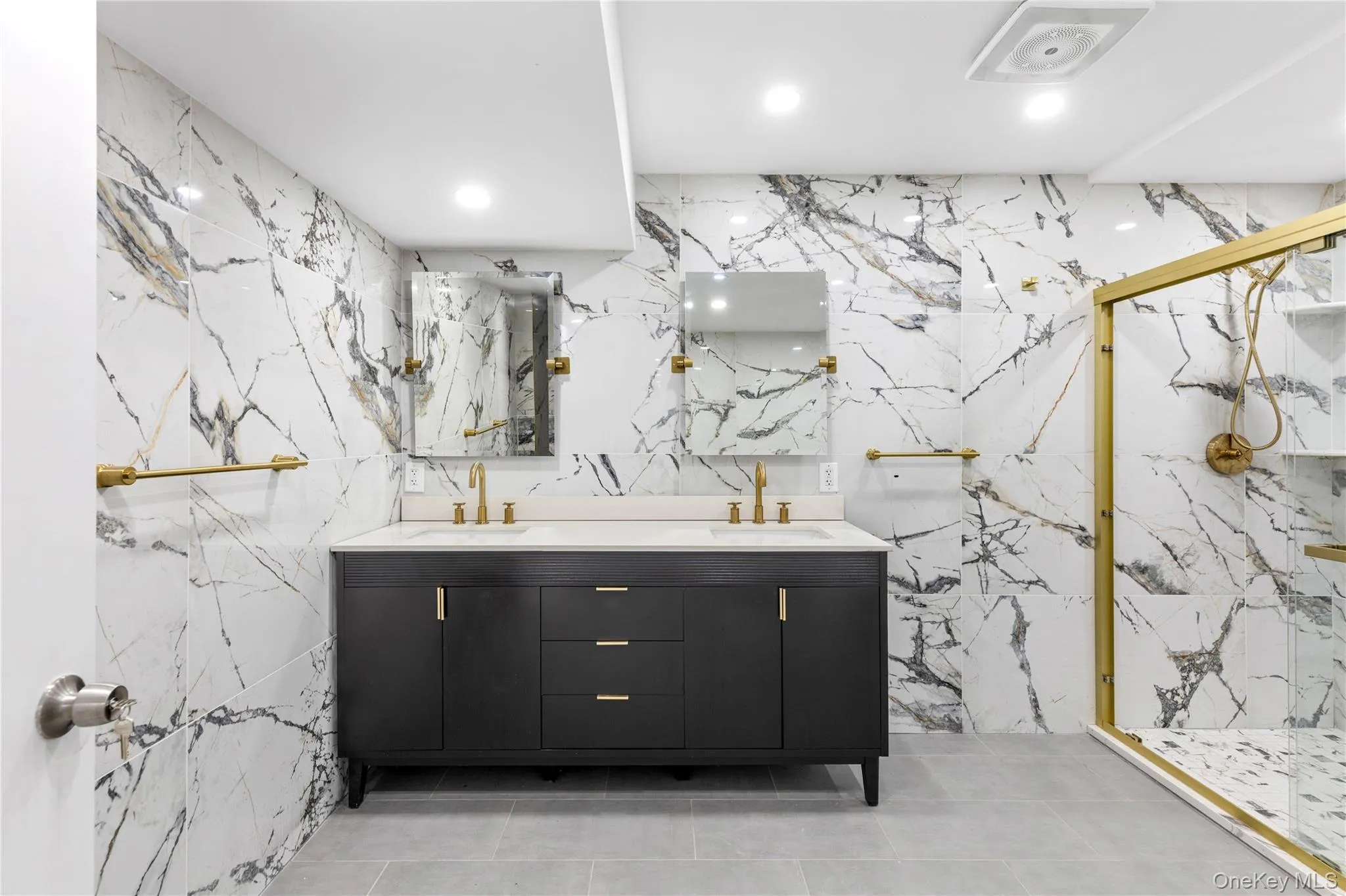Marble-look wall tiling with gold-tone fixtures Marble-look wall tiling with gold-tone fixtures