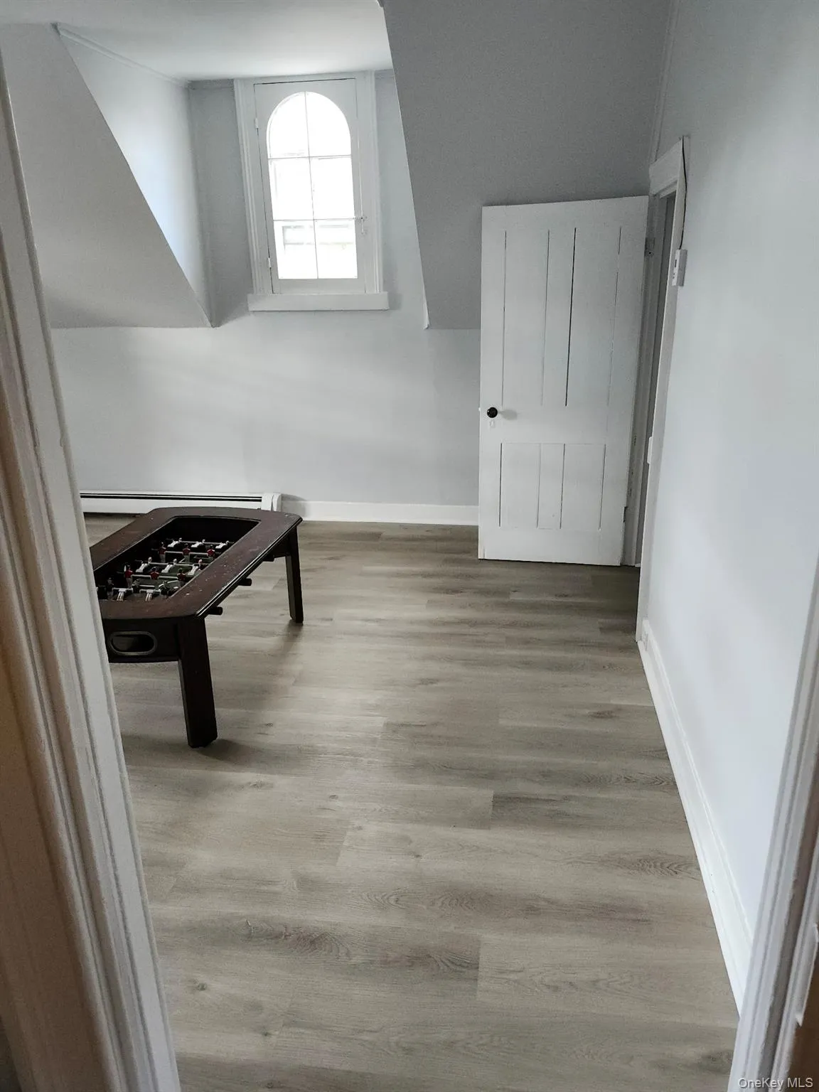 Corridor featuring light hardwood / wood-style flooring and a baseboard radiator Corridor featuring light hardwood / wood-style flooring and a baseboard radiator