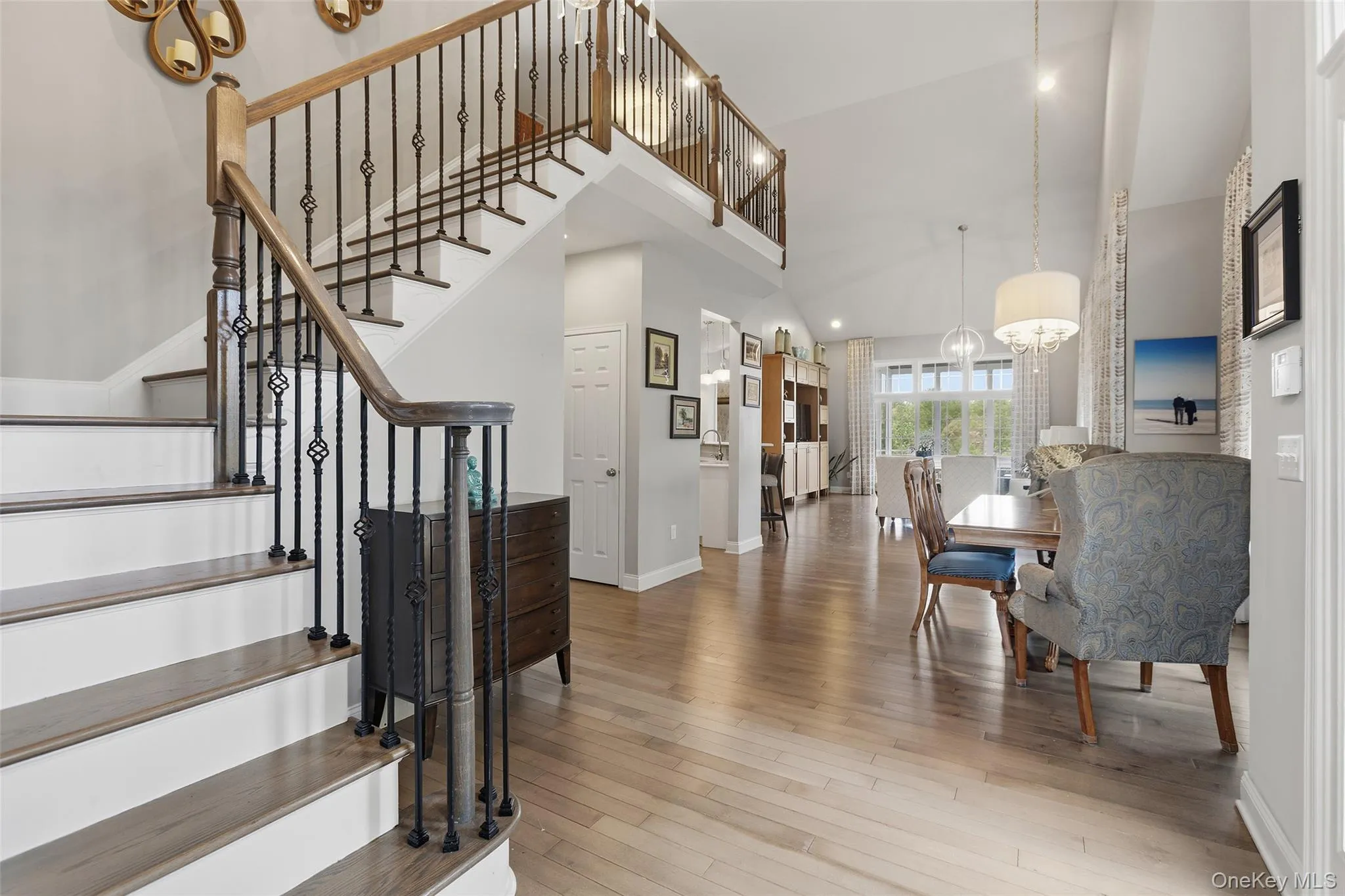 Grand staircase featuring wood treads, white risers, and wrought iron balusters with decorative elements Grand staircase featuring wood treads, white risers, and wrought iron balusters with decorative elements